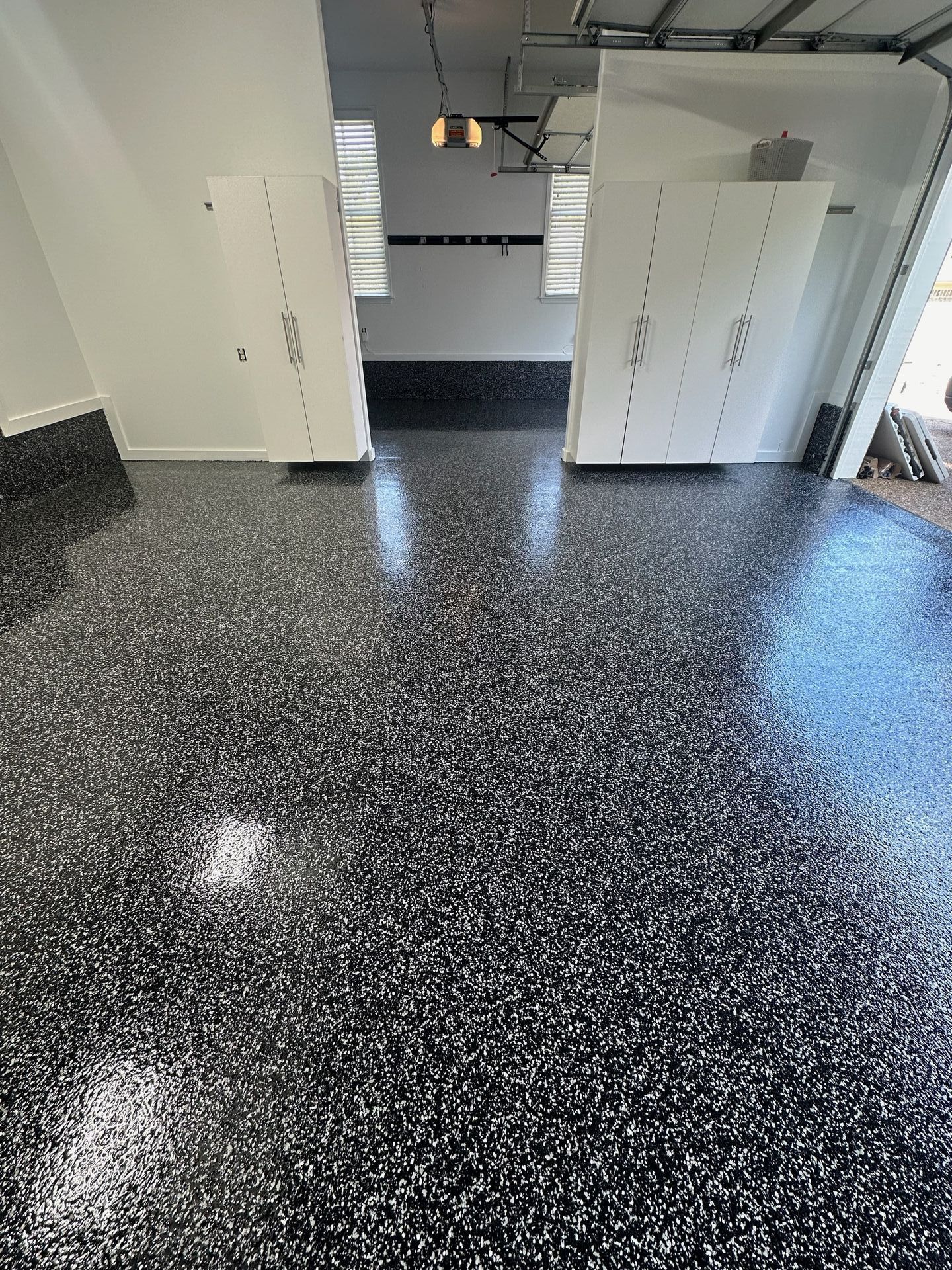 A garage with a black and white floor and white walls.