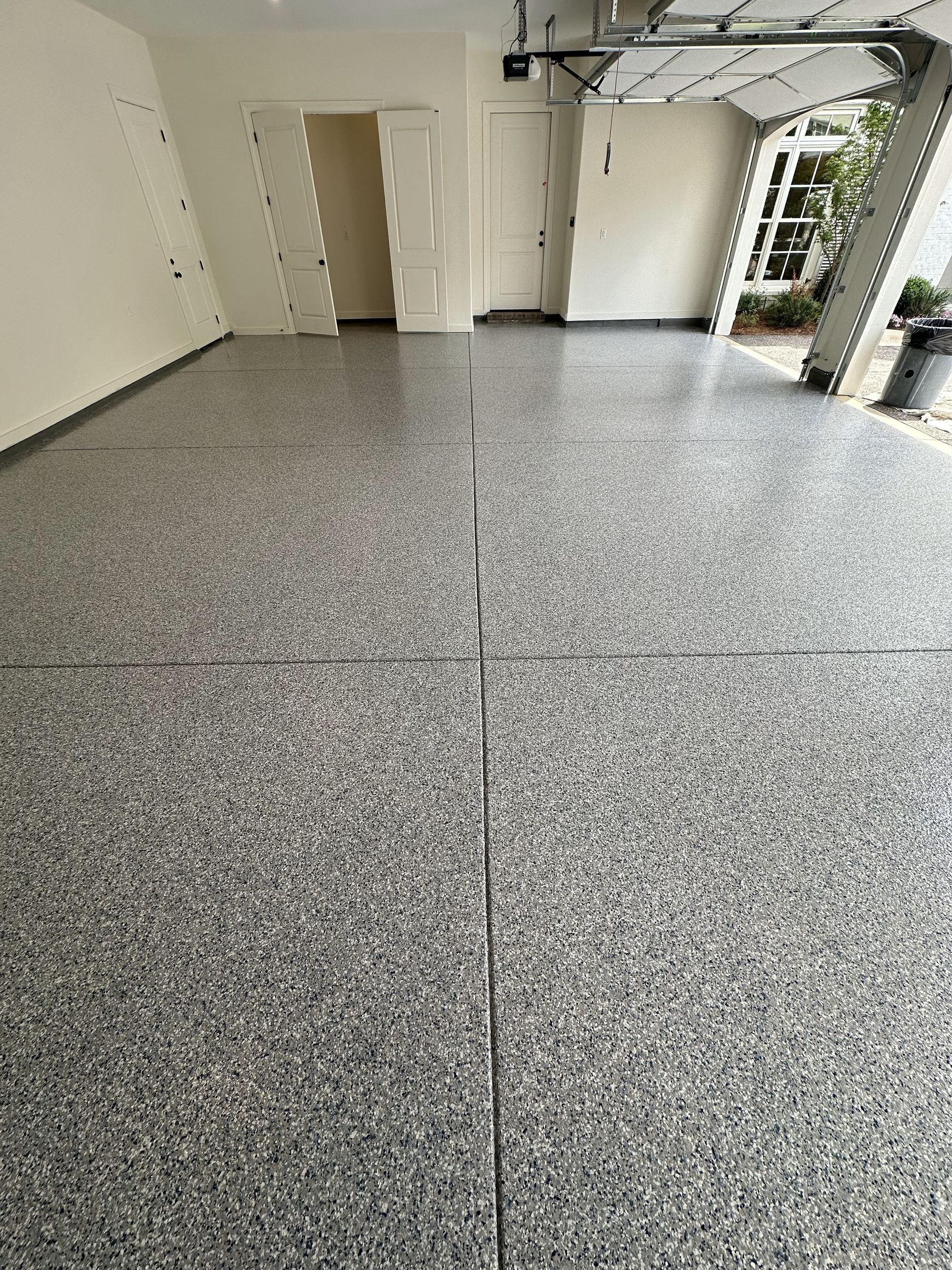 A garage with a gray floor and a white door.
