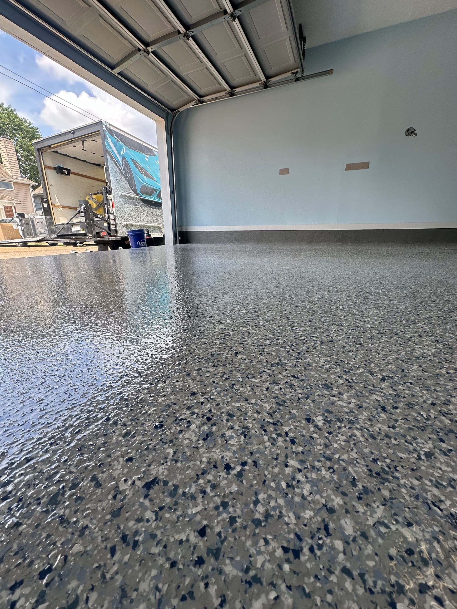A garage with a concrete floor and a boat in the background.