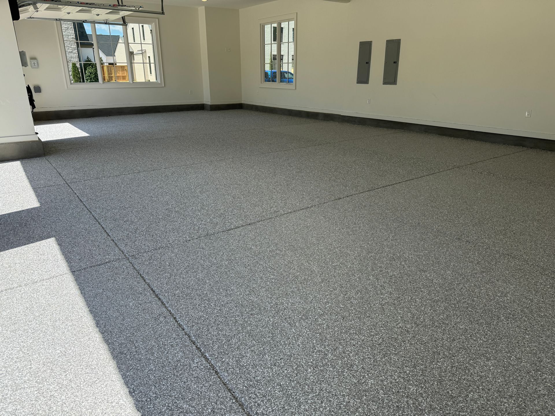 A garage with a gray floor and white walls.
