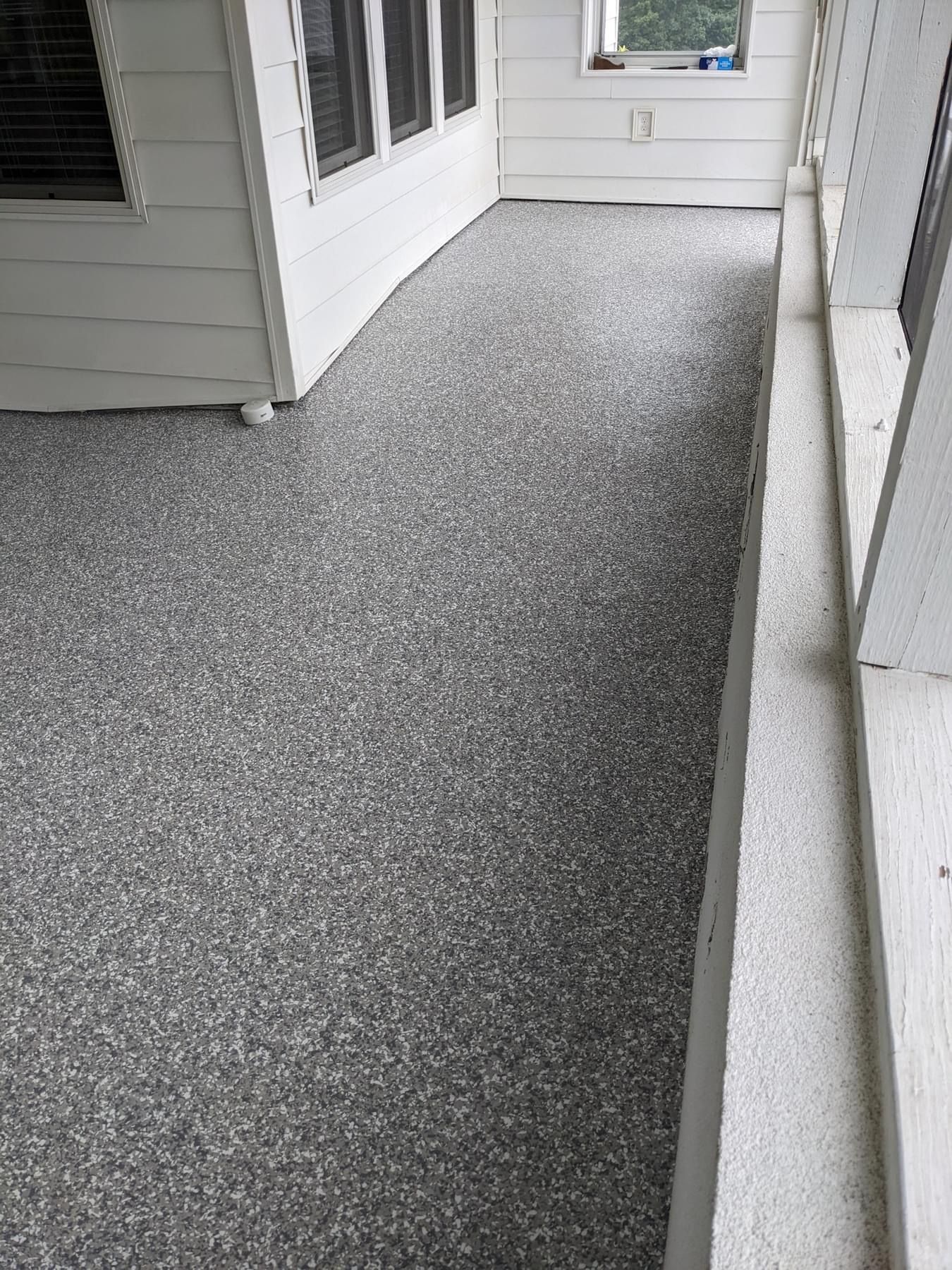 A porch with a concrete floor and a window.