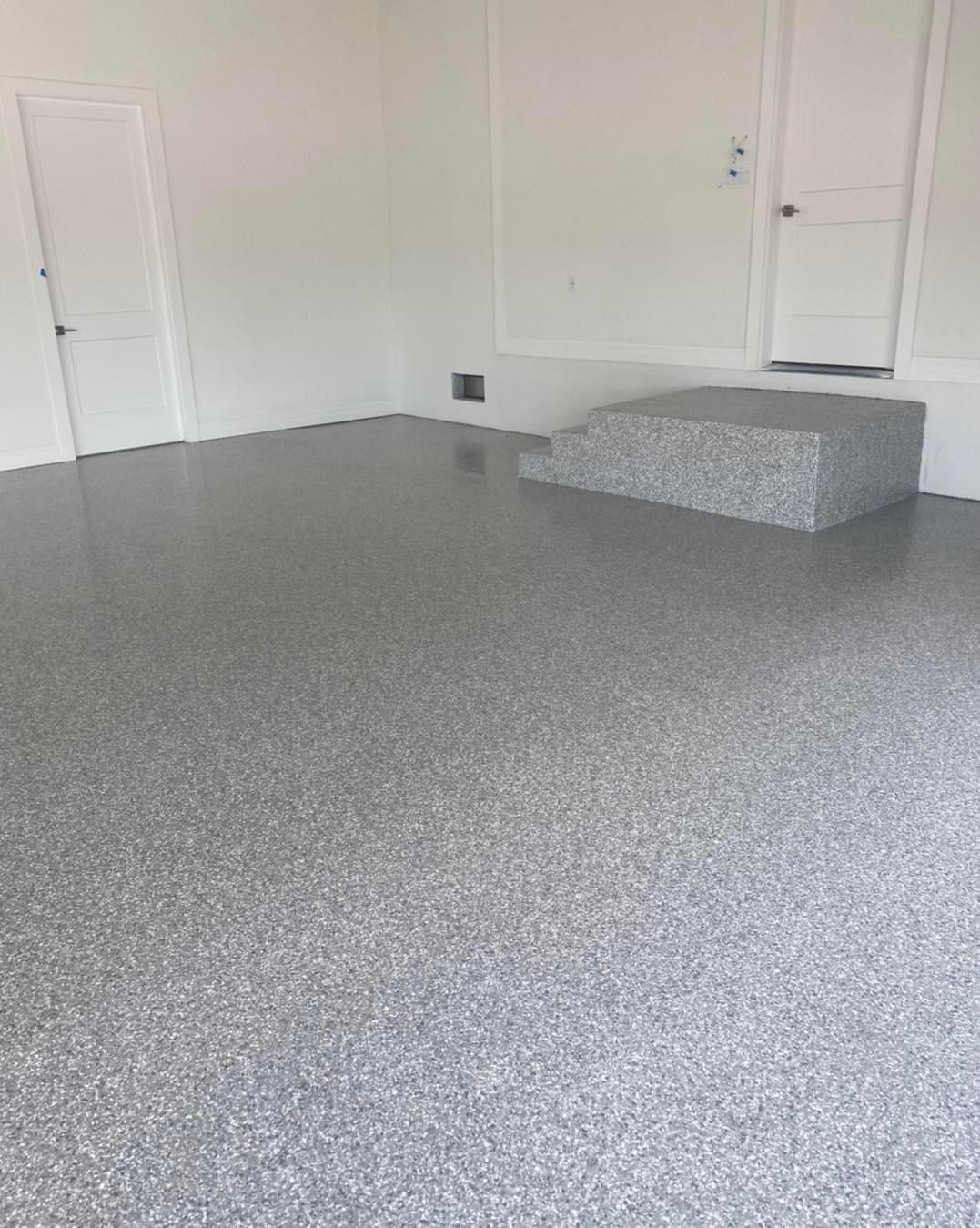A garage with a gray floor and white walls.