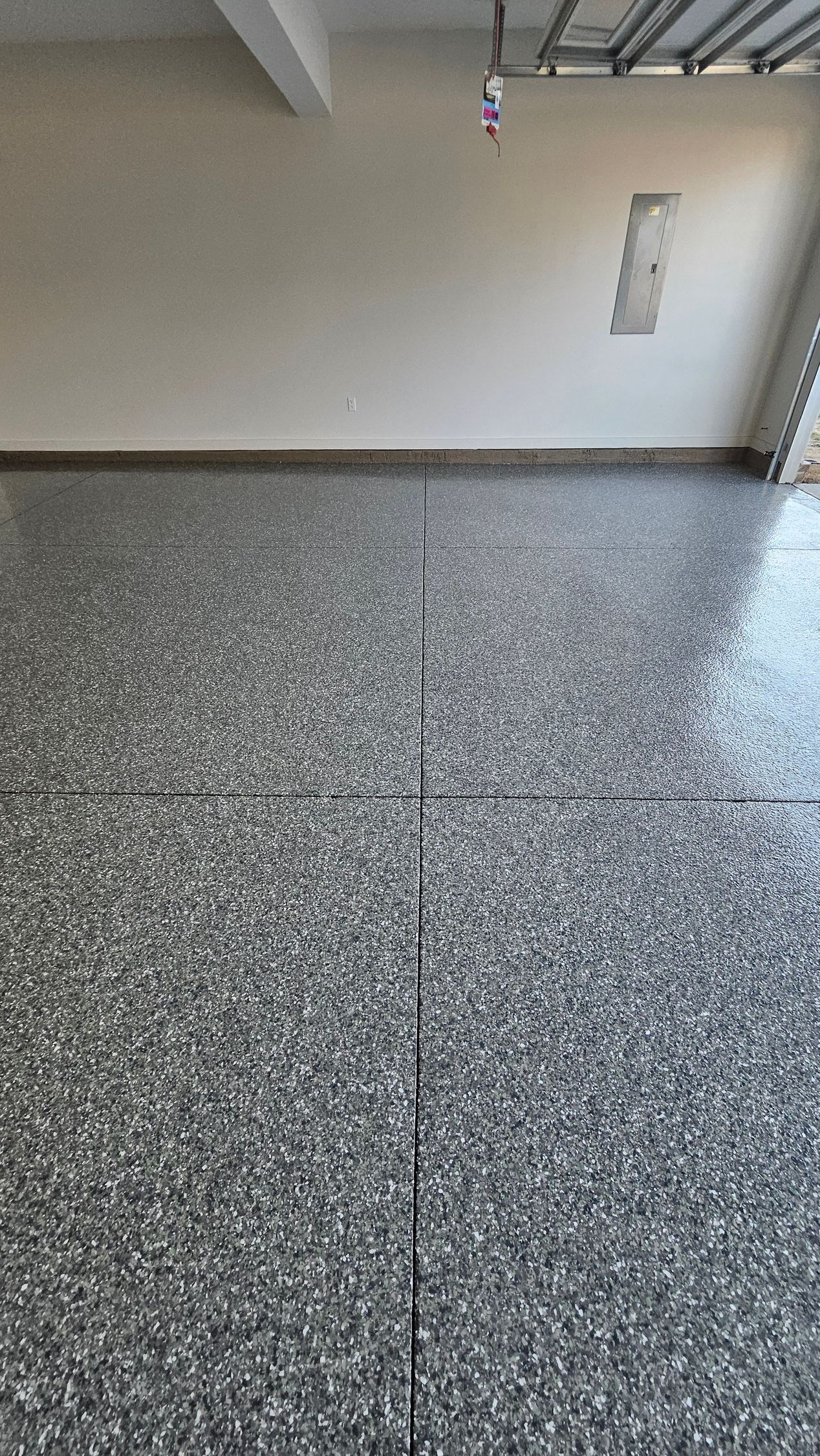 Garage floor with speckled gray and white tiles.
