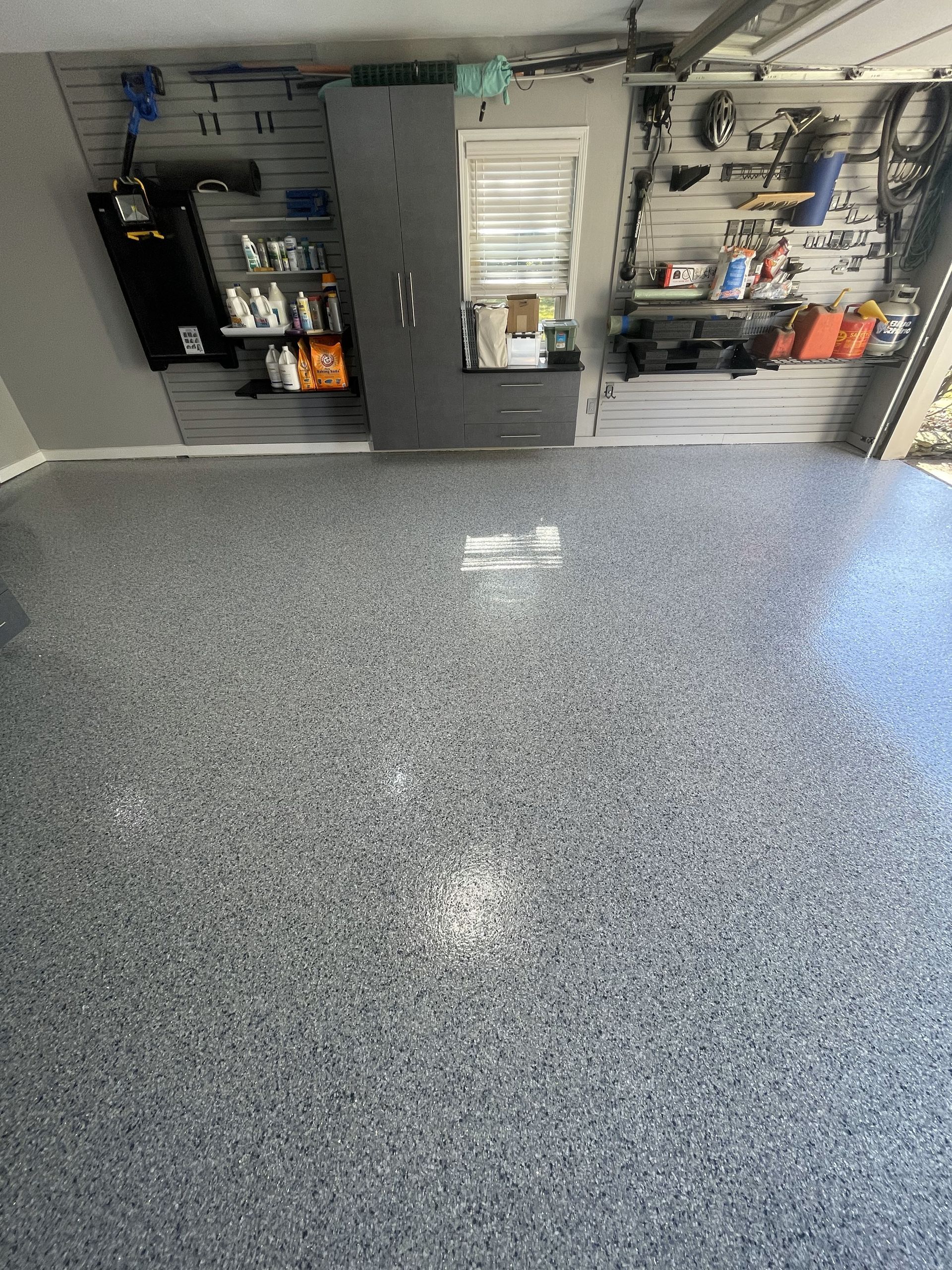 A garage with a gray floor and a lot of storage space.