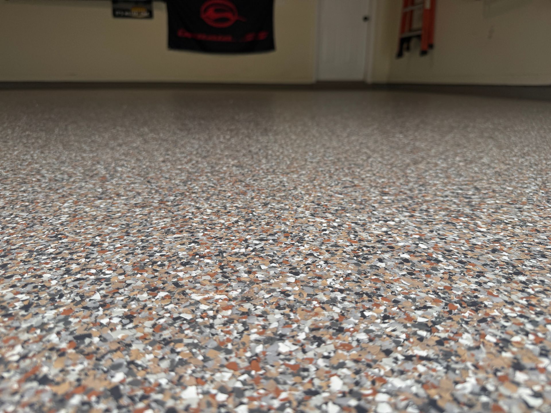 A close up of a garage floor with a flag hanging on the wall.