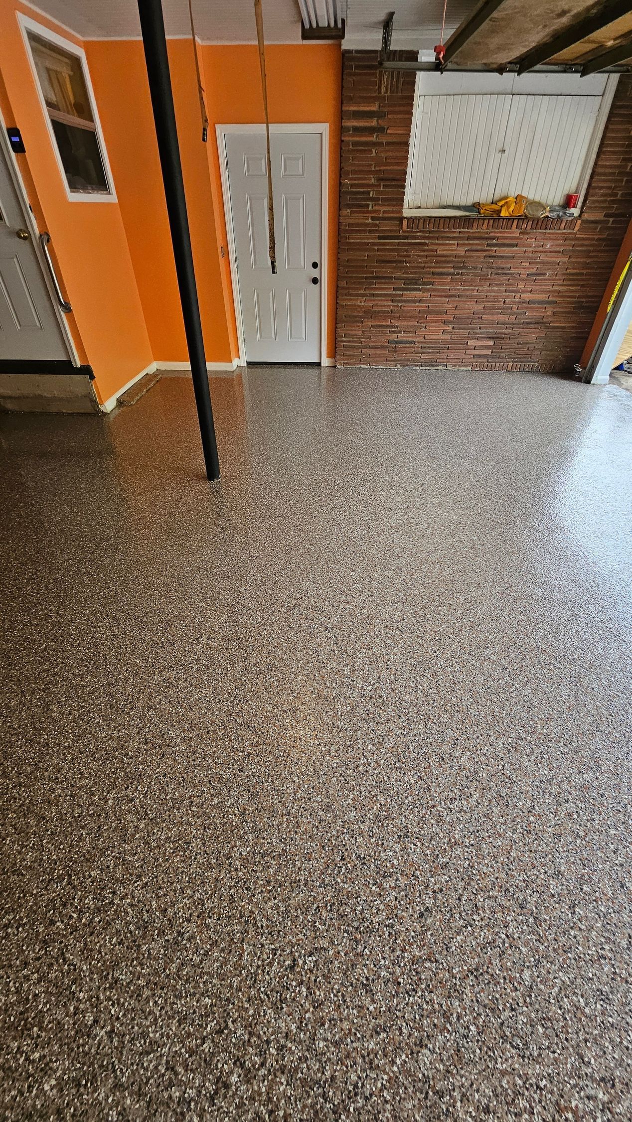 A room with a concrete floor and a brick wall.