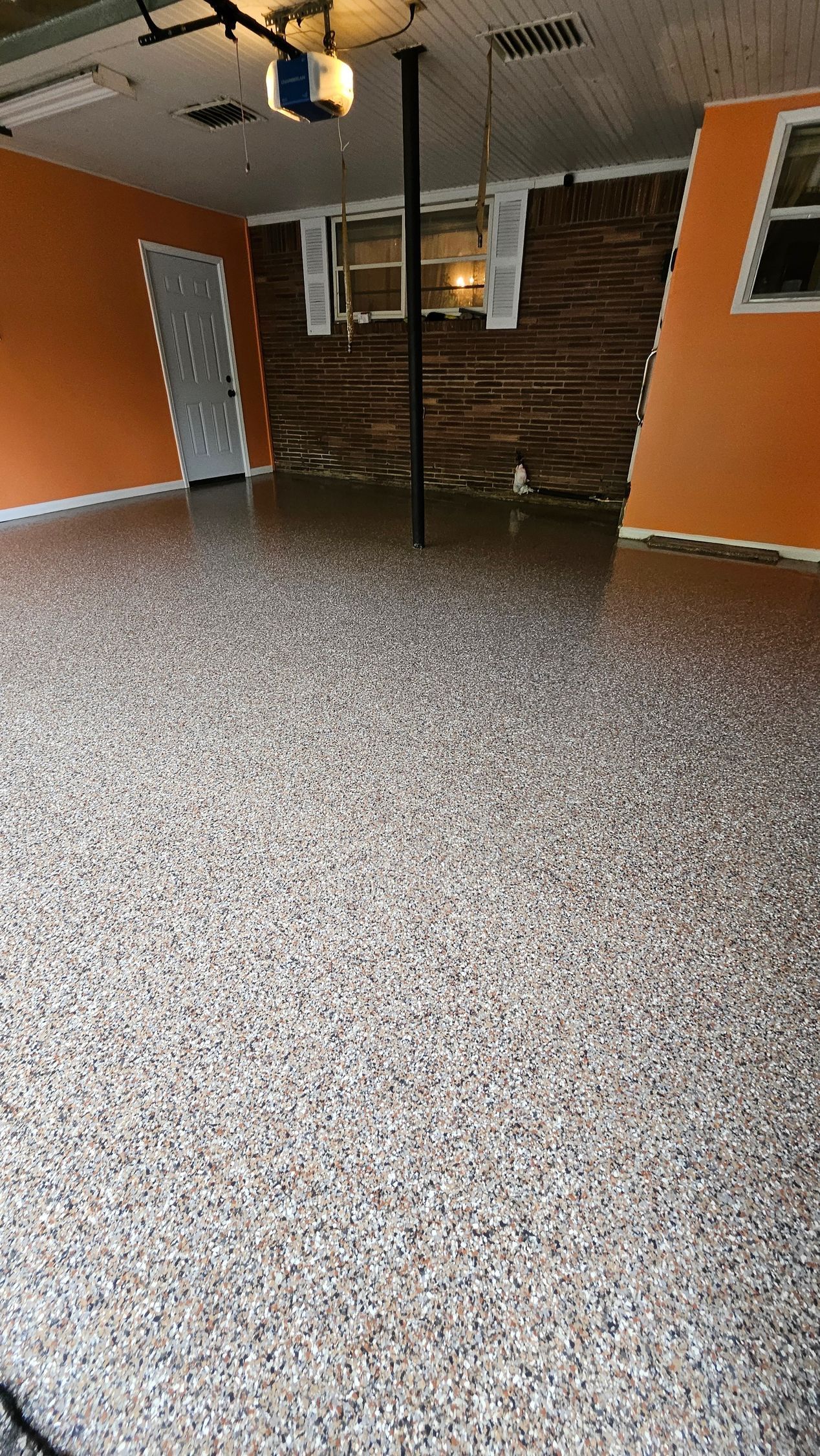 A garage with a concrete floor and orange walls.