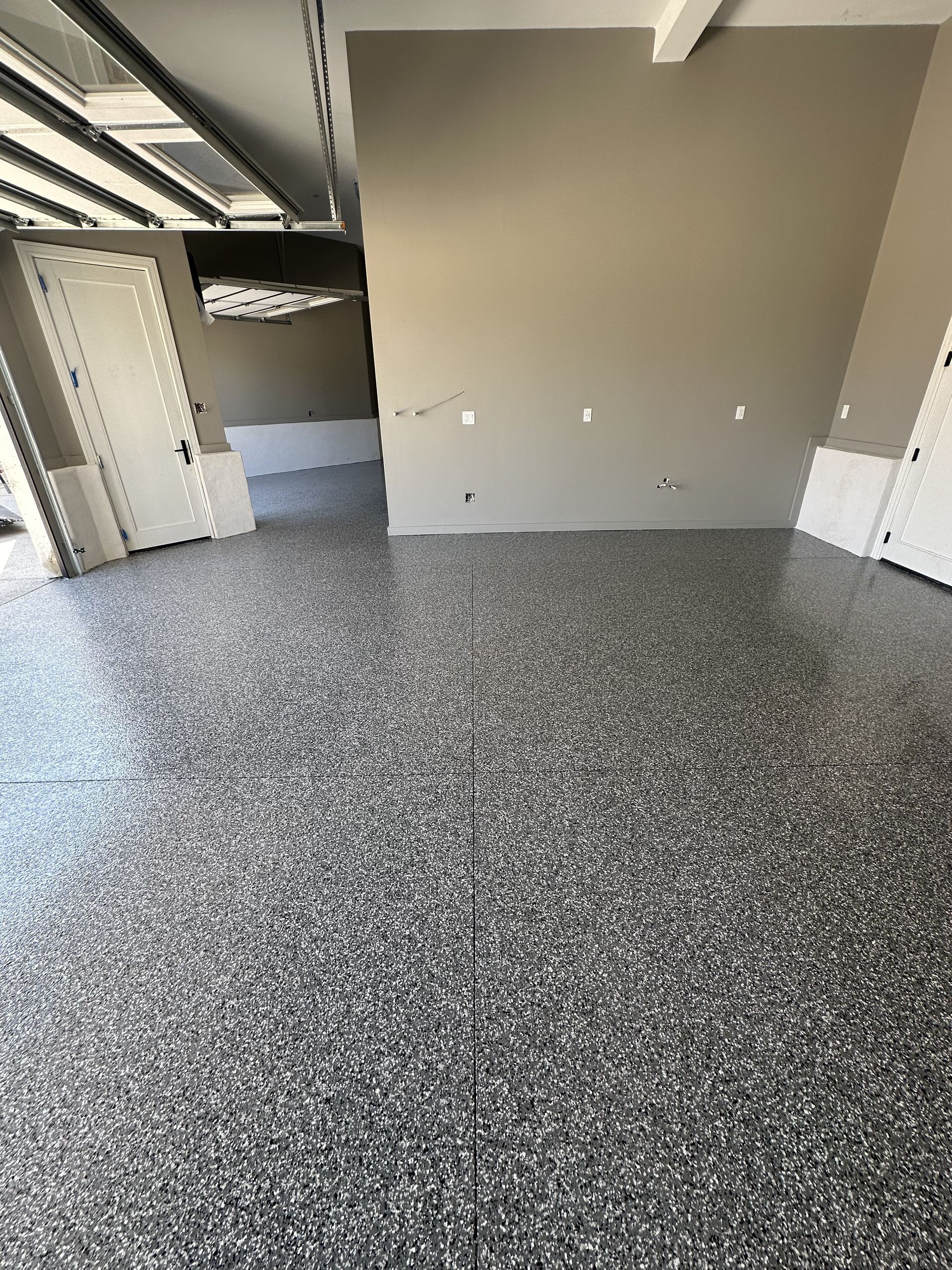 A large kitchen with stainless steel appliances and a gray floor.