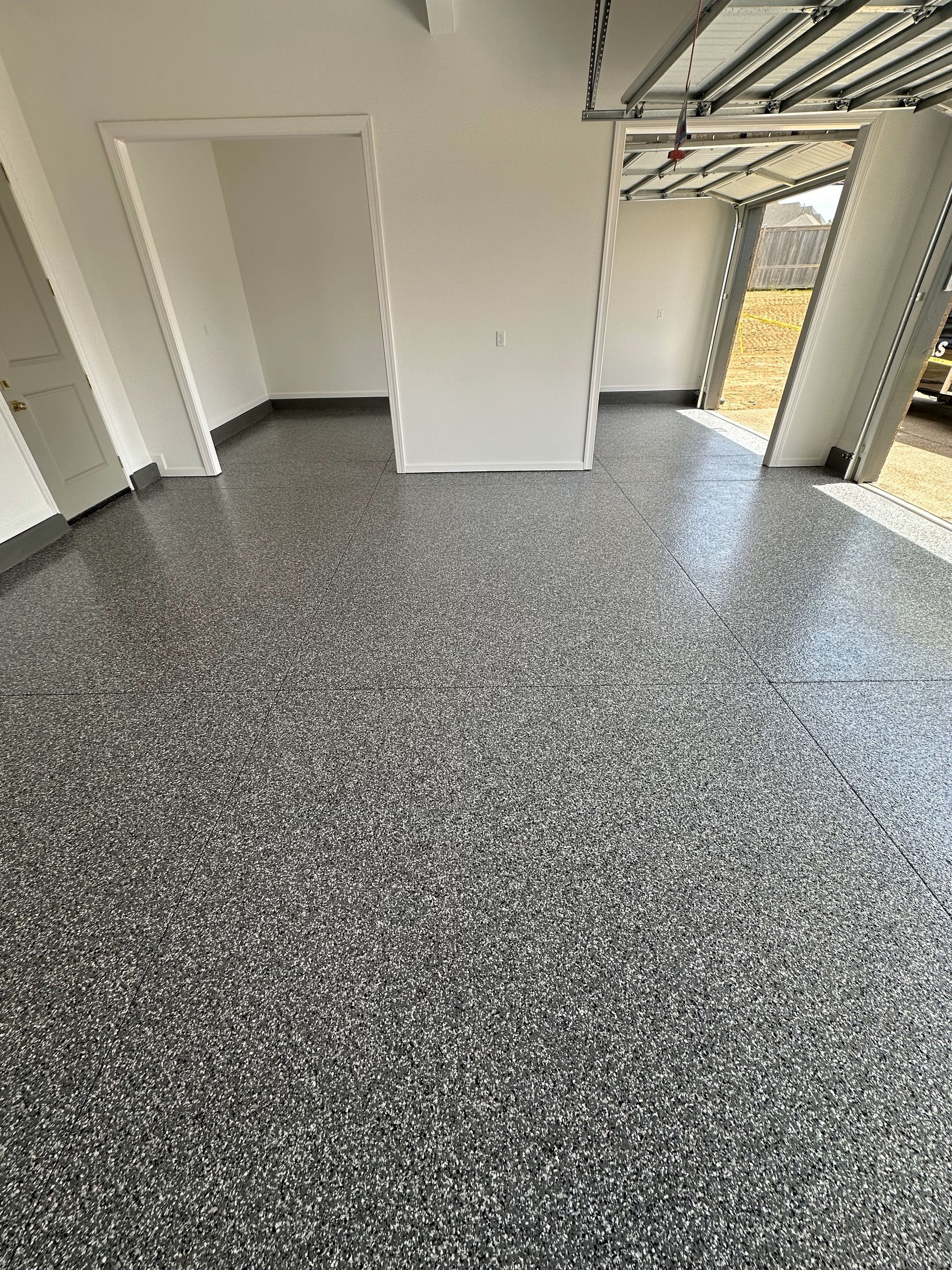 A garage with a gray floor and white walls.