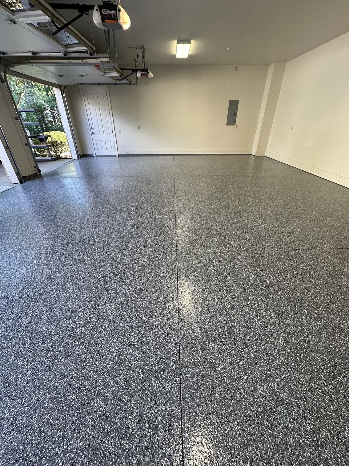 A garage with a gray floor and white walls.