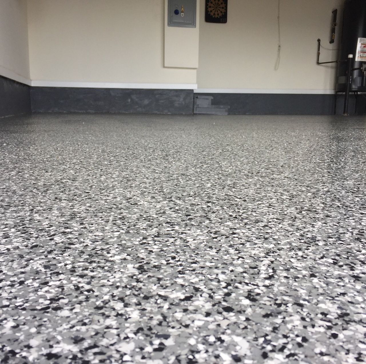 A close up of a gray and white floor in a garage.