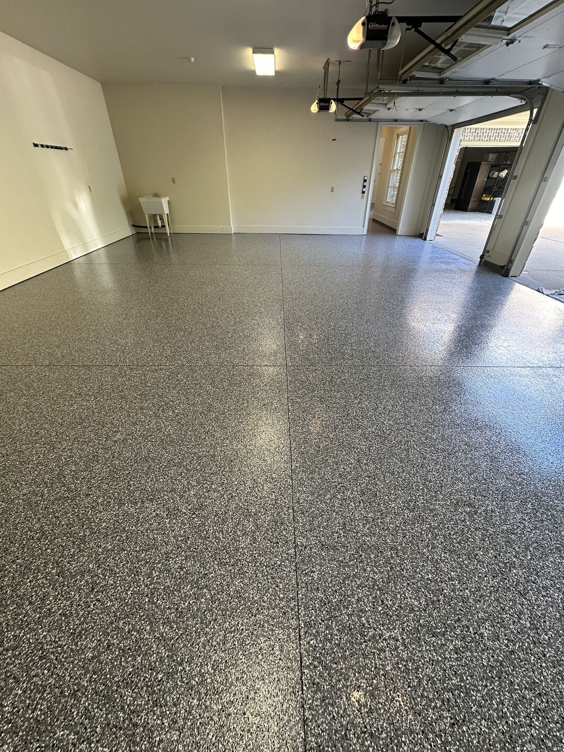 A garage with a gray floor and a white wall.