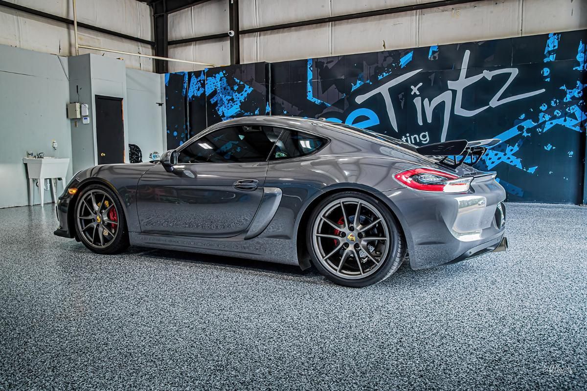 Dark gray sports car in a window tinting shop with epoxy garage floor
