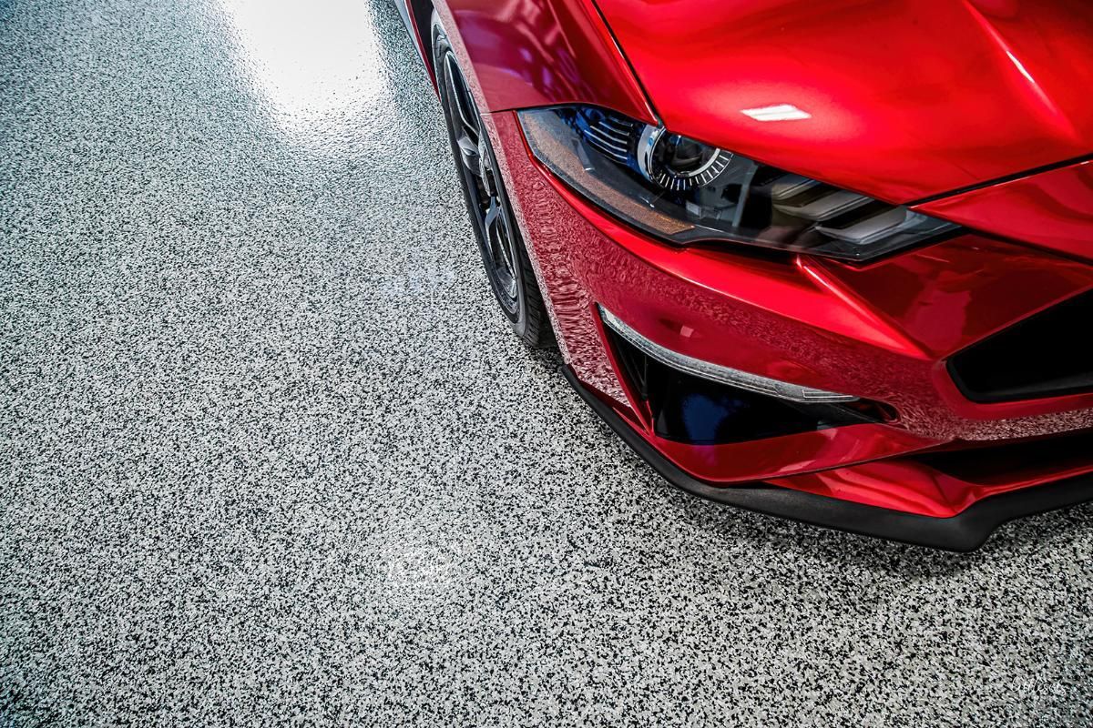 Red sports car in a window tinting shop with epoxy garage floor