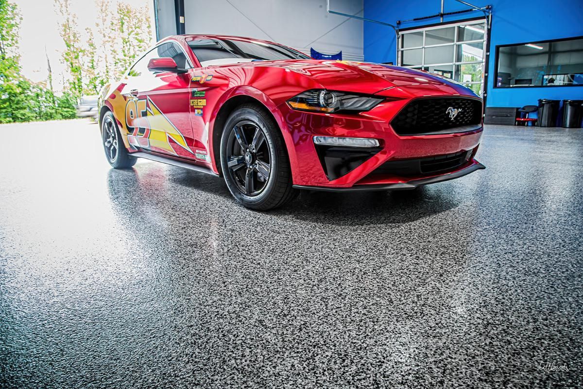 Red sports car in a window tinting shop with epoxy garage floor