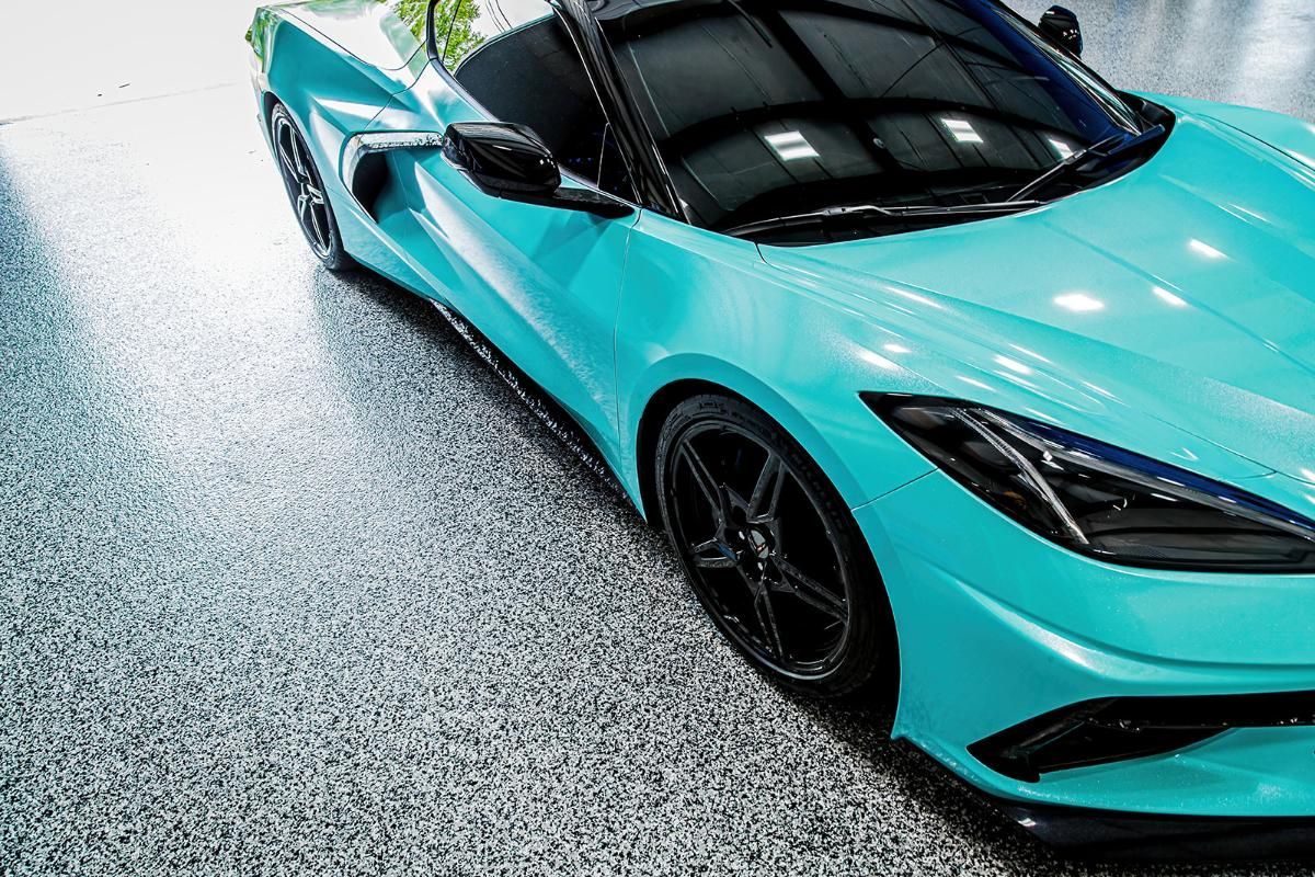 Blue sports car in a window tinting shop with epoxy garage floor