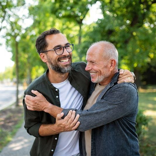 Senior Man With His Mature Son Embracing Each Other - Beatrice, NE - Gleason Dental Clinic