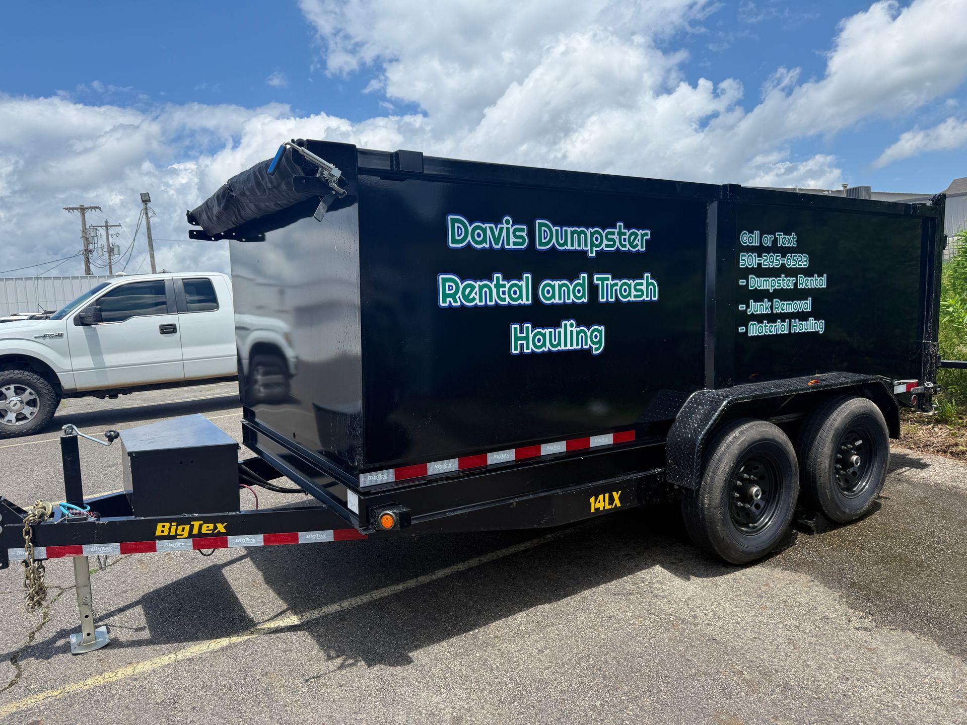 Black dumpster trailer with text 