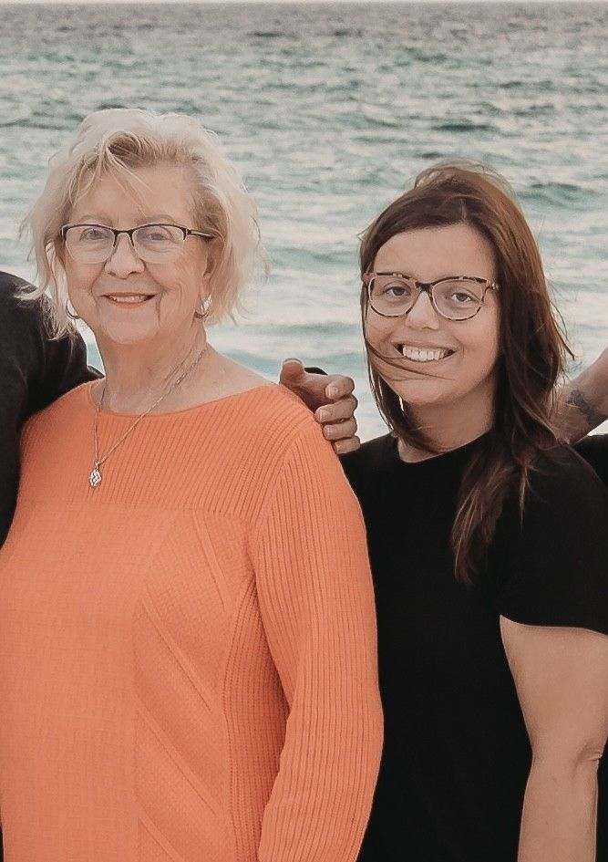 A green truck is parked in a parking lot in front of a building.