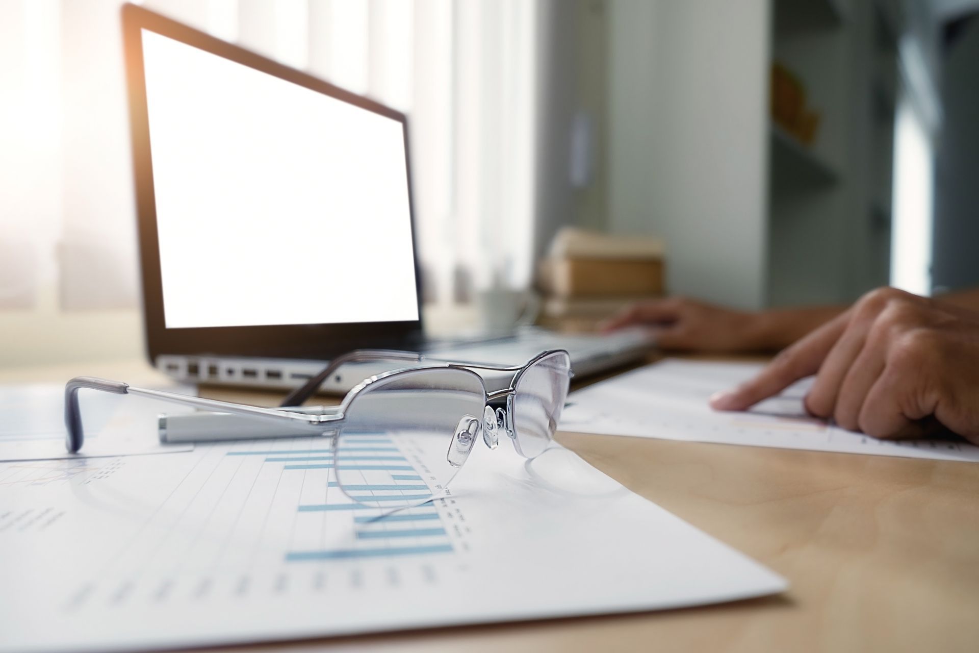 A person is sitting at a desk holding a receipt and a pen.