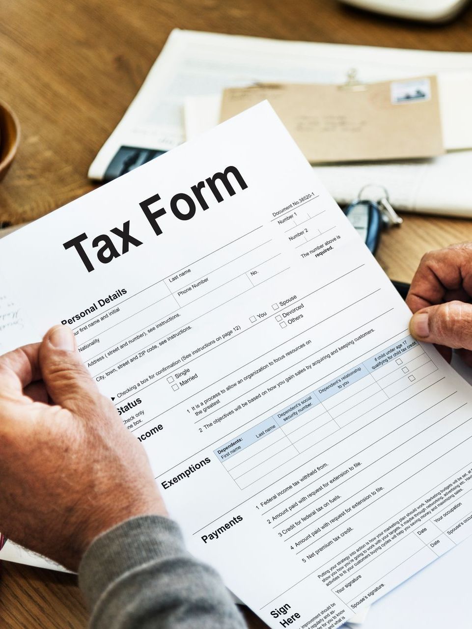 A person is holding a tax form in their hands.