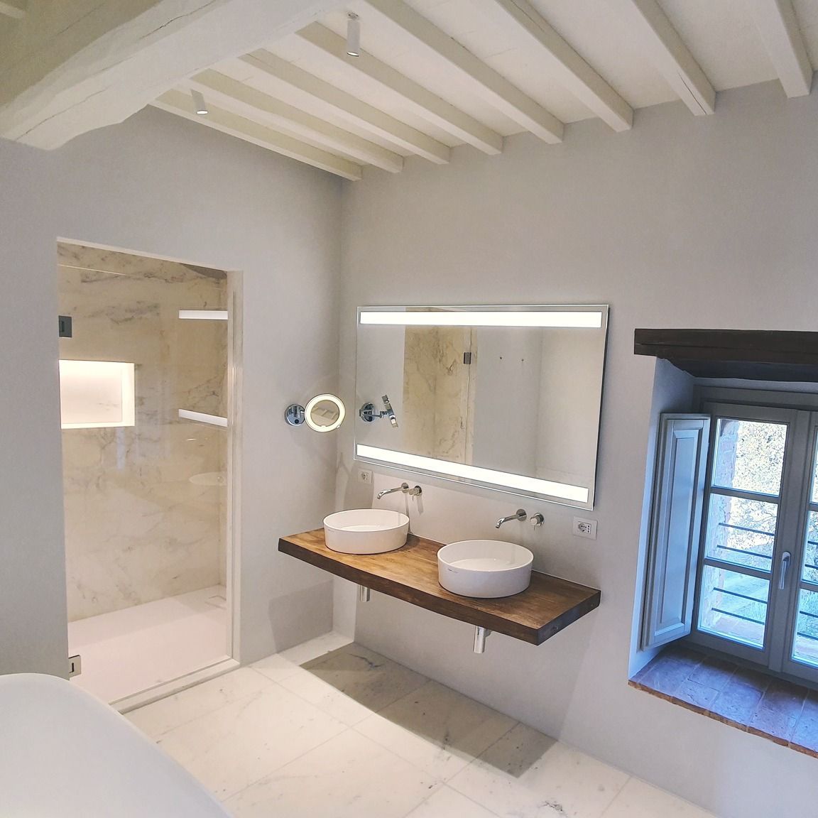 Persone che esaminano progetti architettonici, campioni di colori e campioni di ante di armadi su una scrivania.