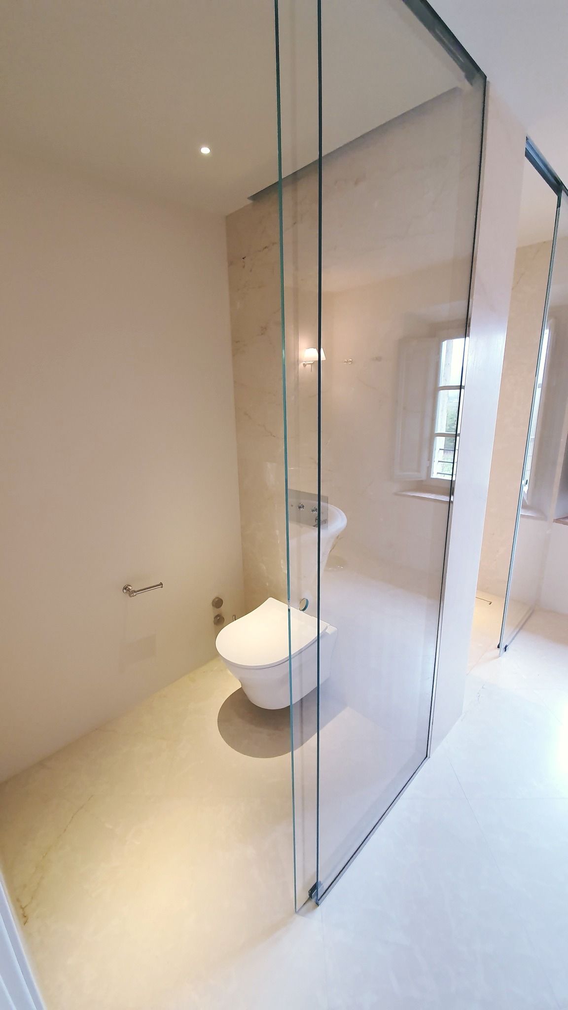 Uomo che esamina campioni di tessuto in uno studio di design, tenendo in mano i campioni e osservando l'esposizione.