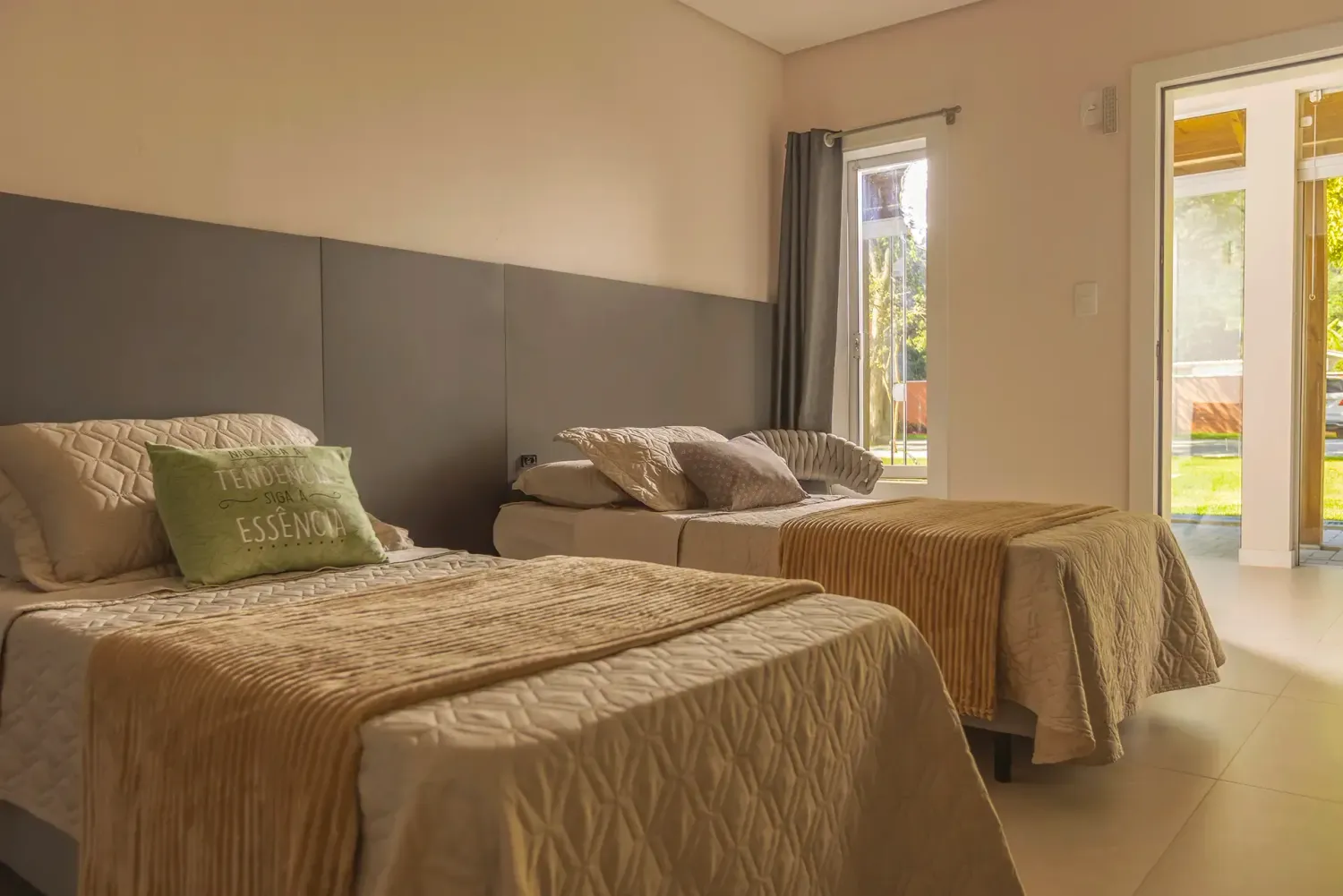 Um quarto com duas camas, um sofá e uma janela.