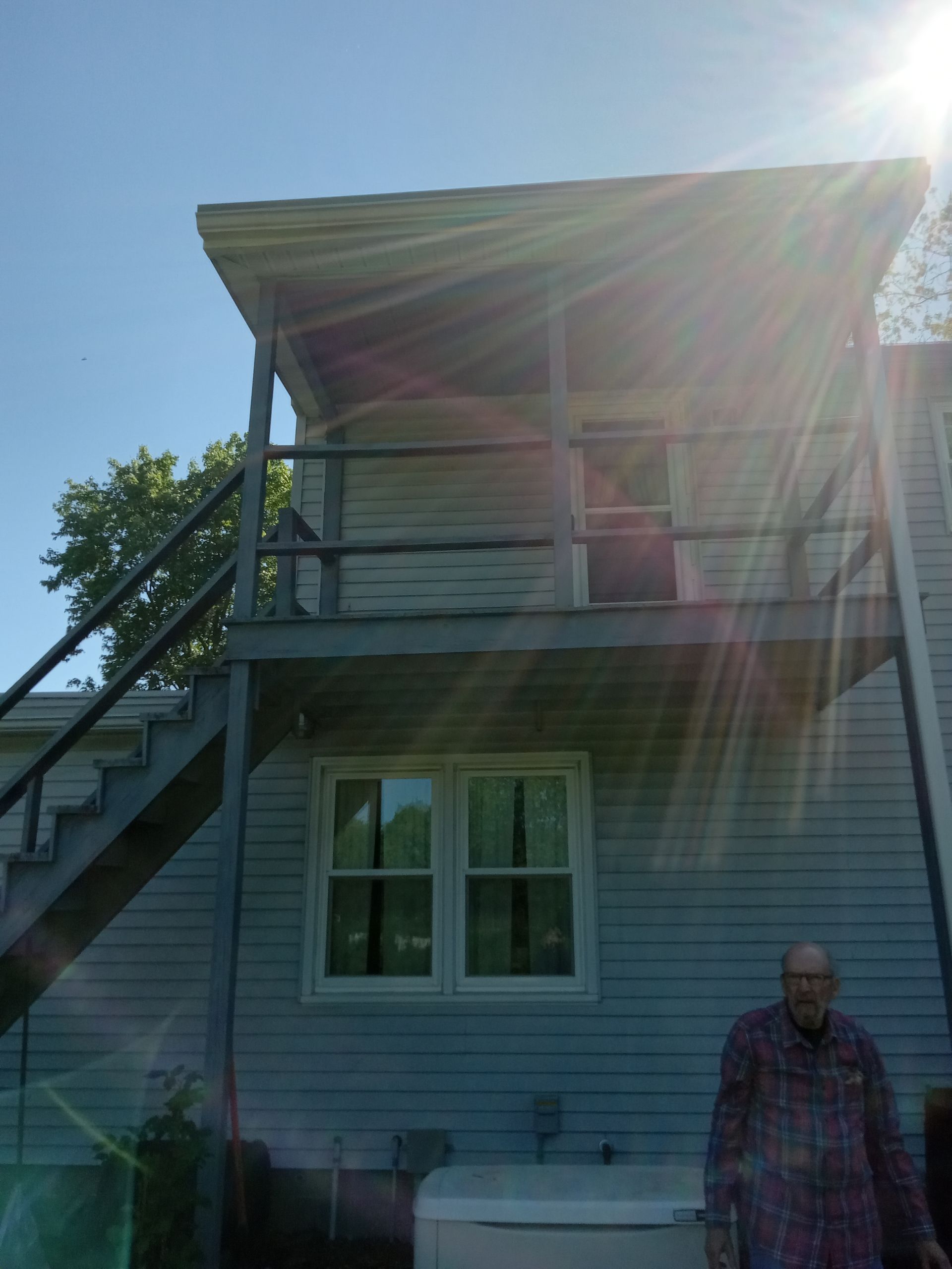 A man standing in front of a house with stairs