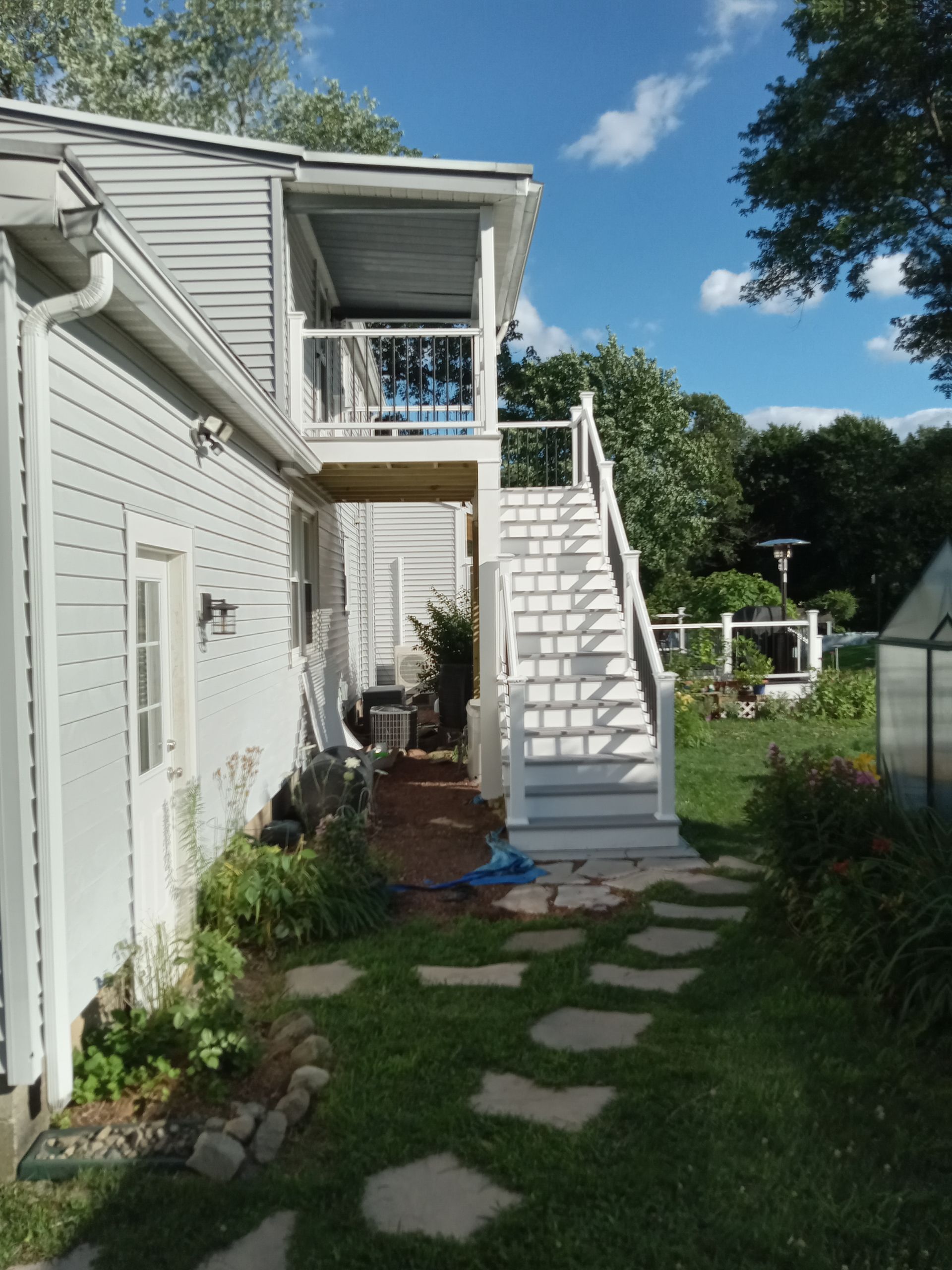 A white house with stairs leading up to the second floor