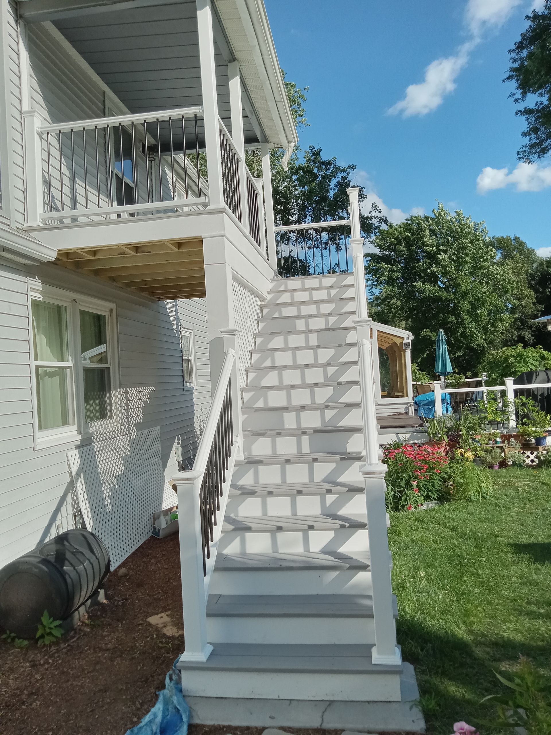 A white house with stairs leading up to a deck