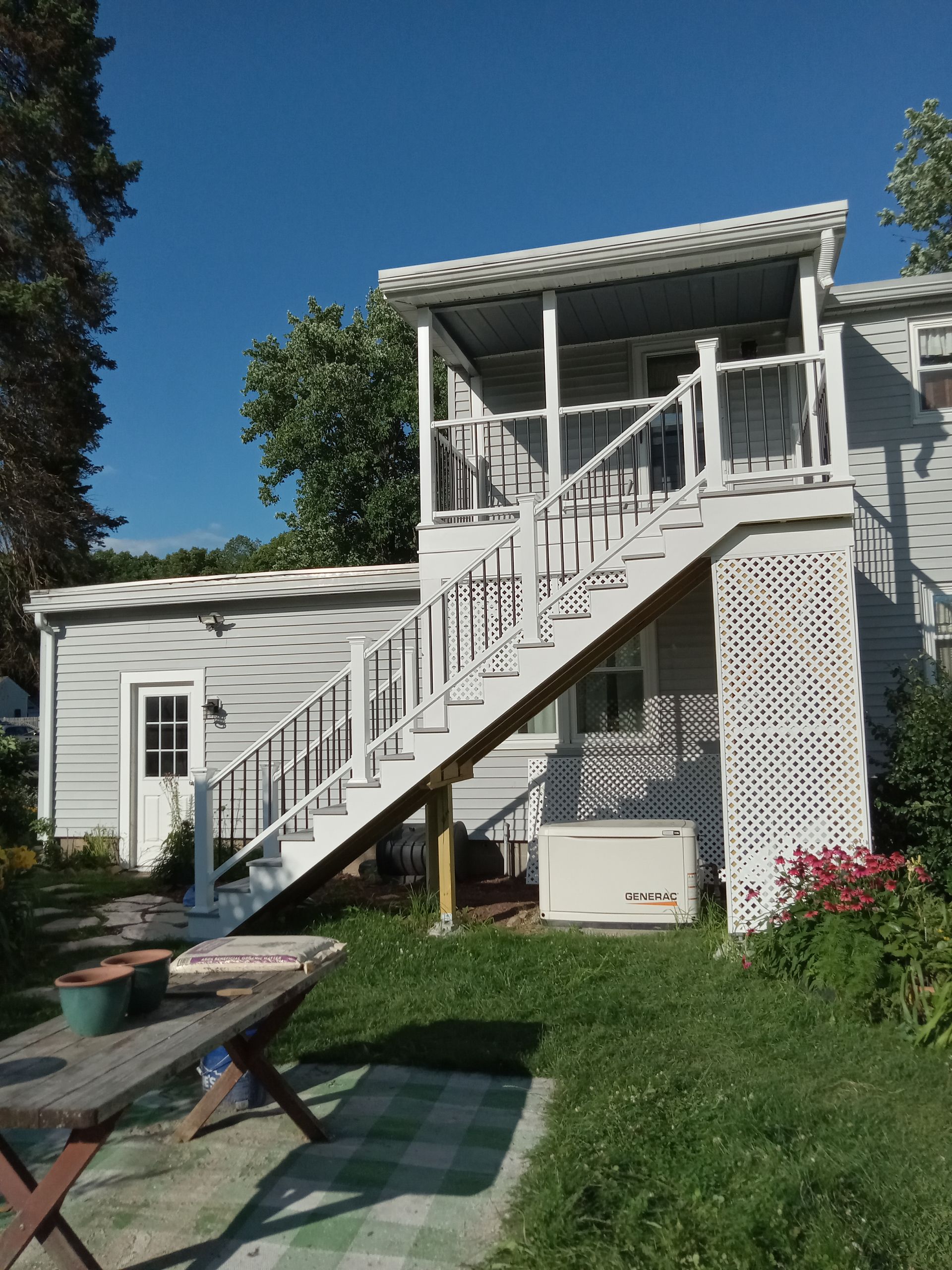 A white house with stairs leading up to the second floor