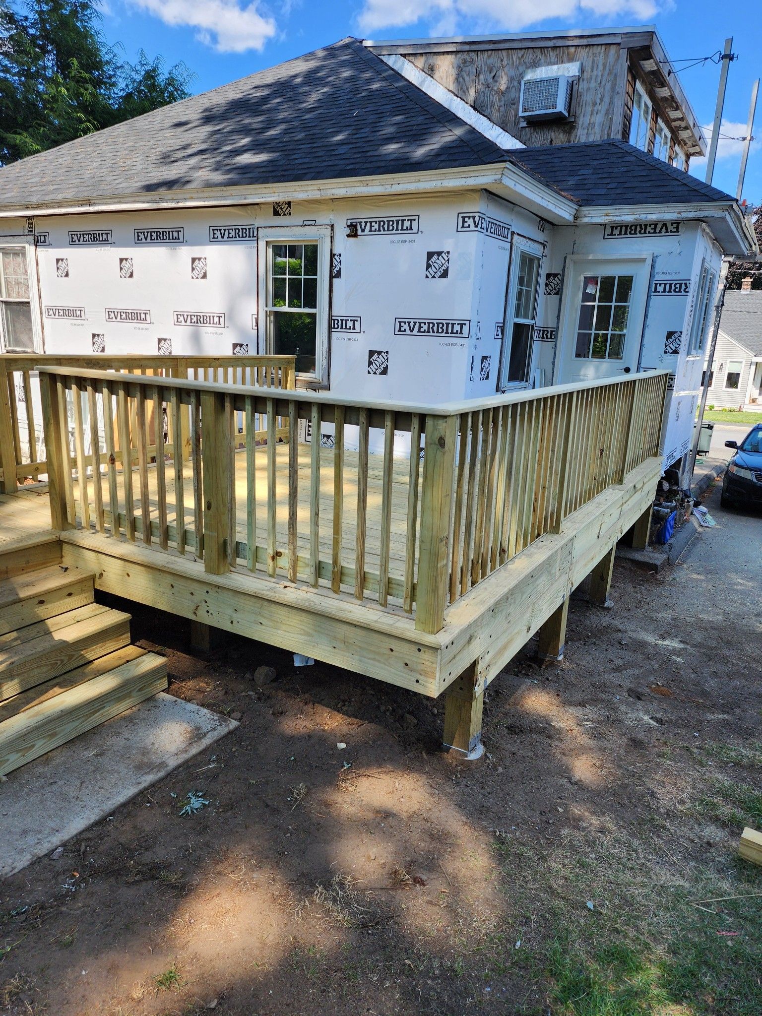 A wooden deck is being built on the side of a house.