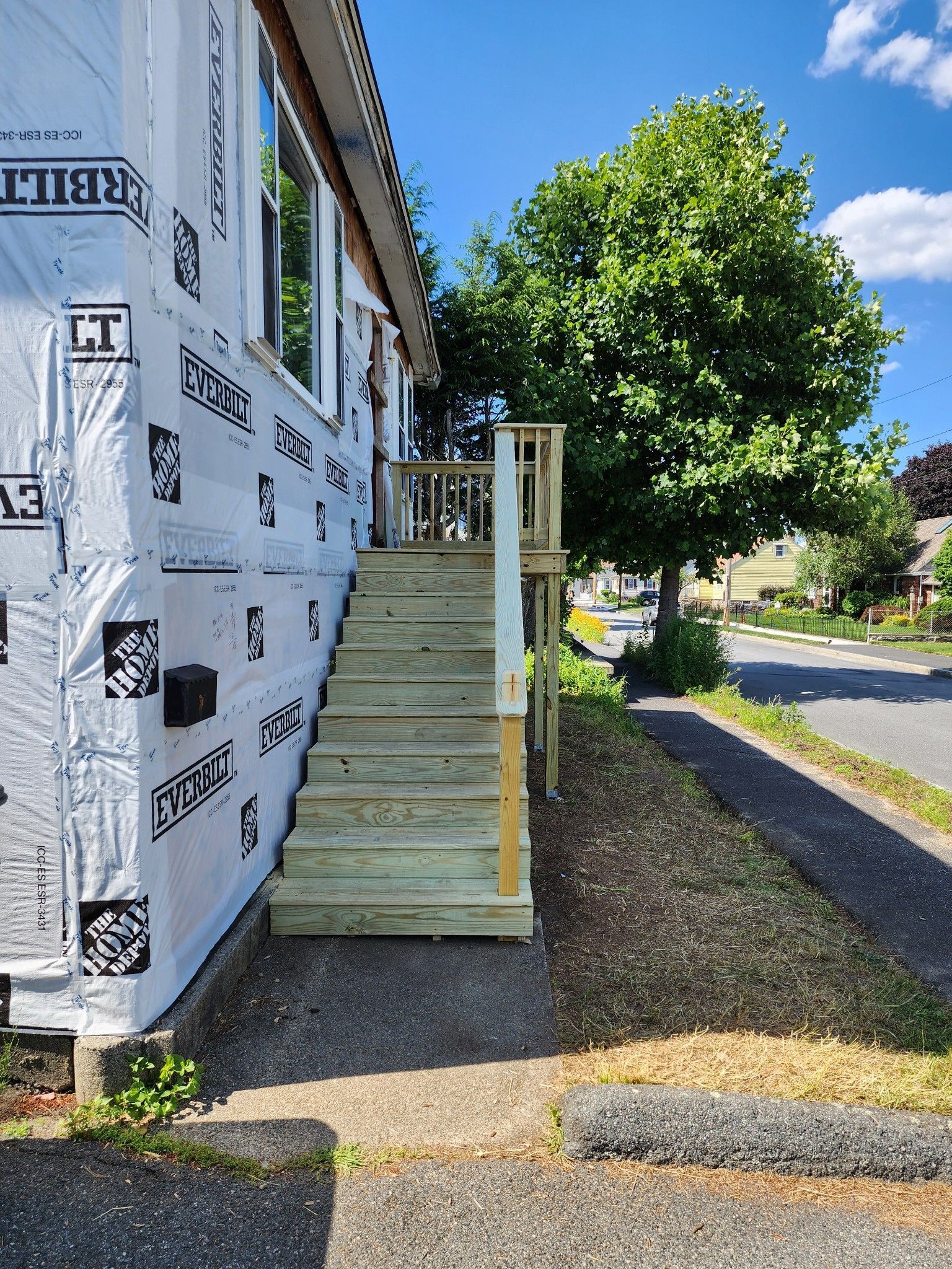 A house with a wooden deck and stairs on the side of it