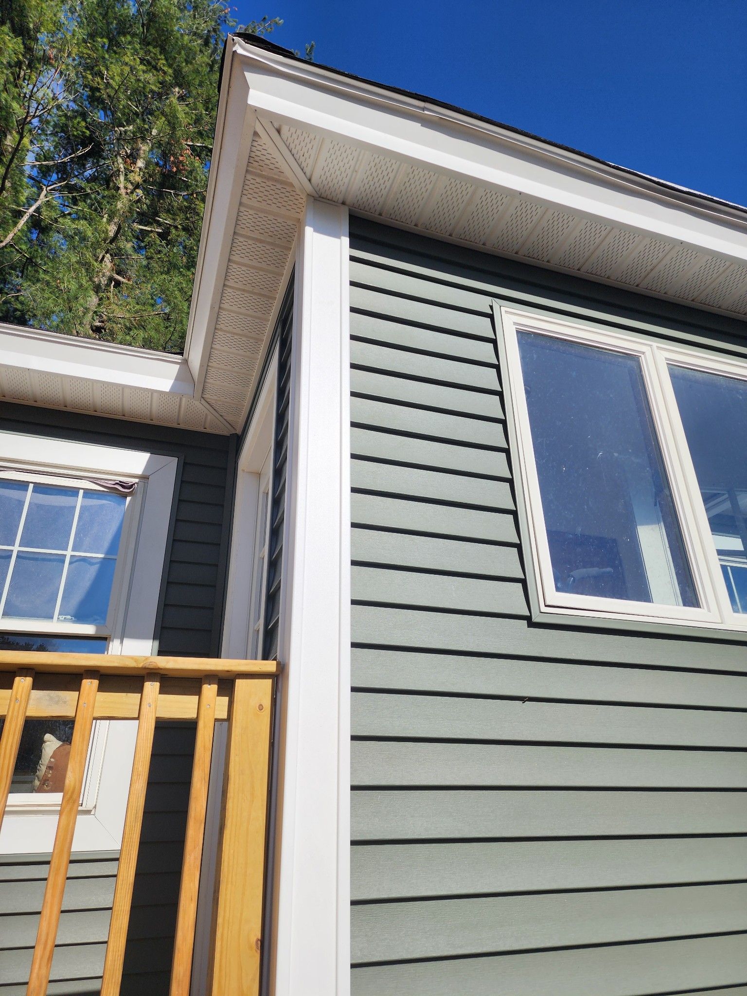 A house with a balcony and a blue sky in the background