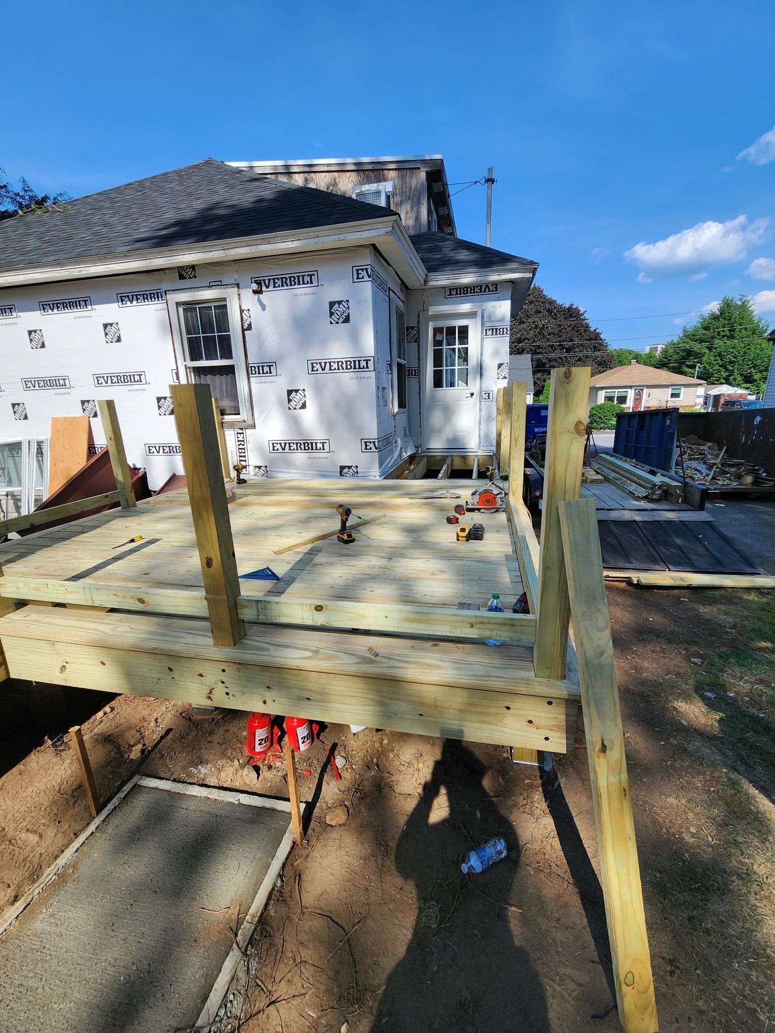 A wooden deck is being built in front of a house.