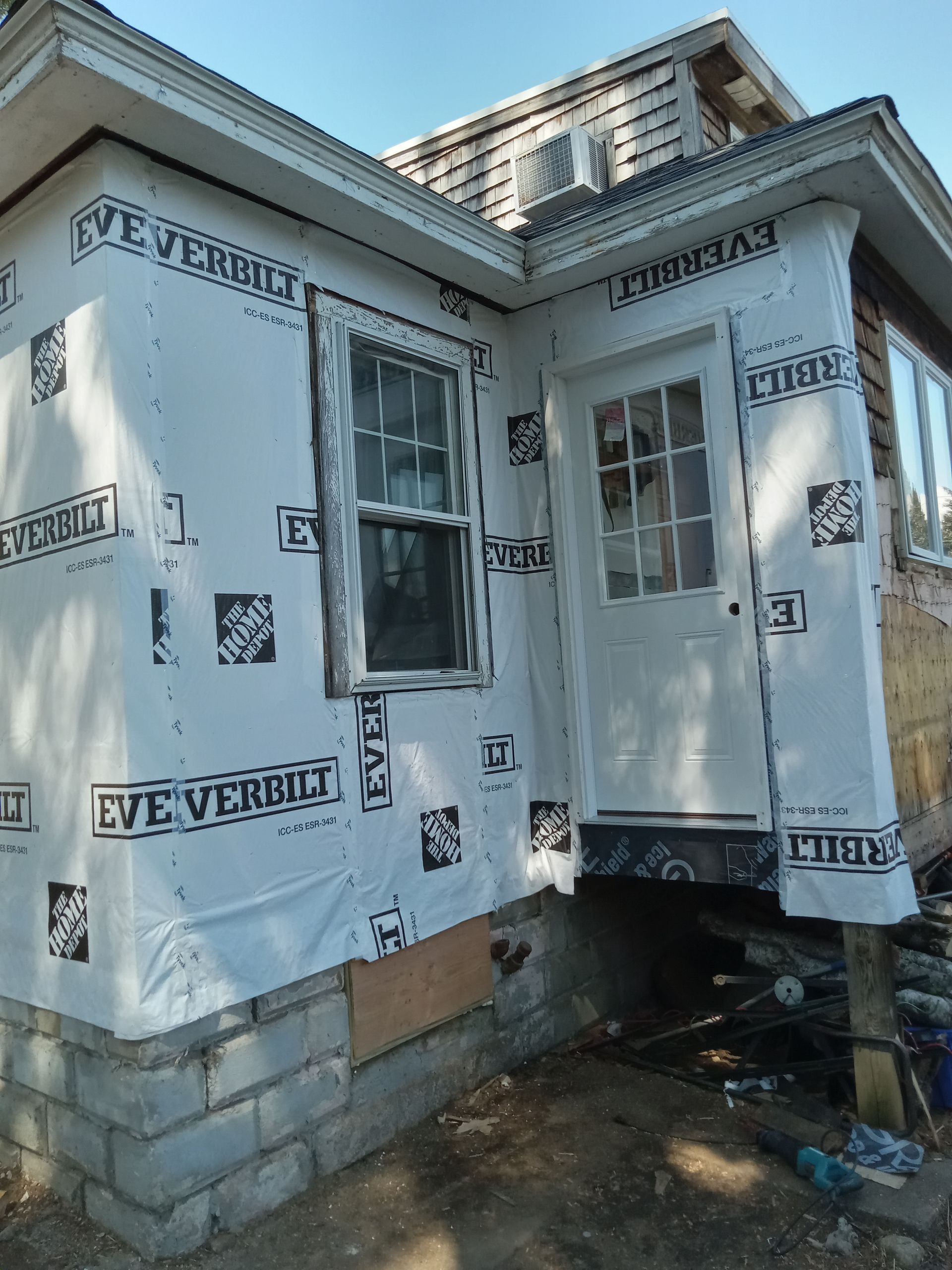 A house with a window and door is being remodeled.