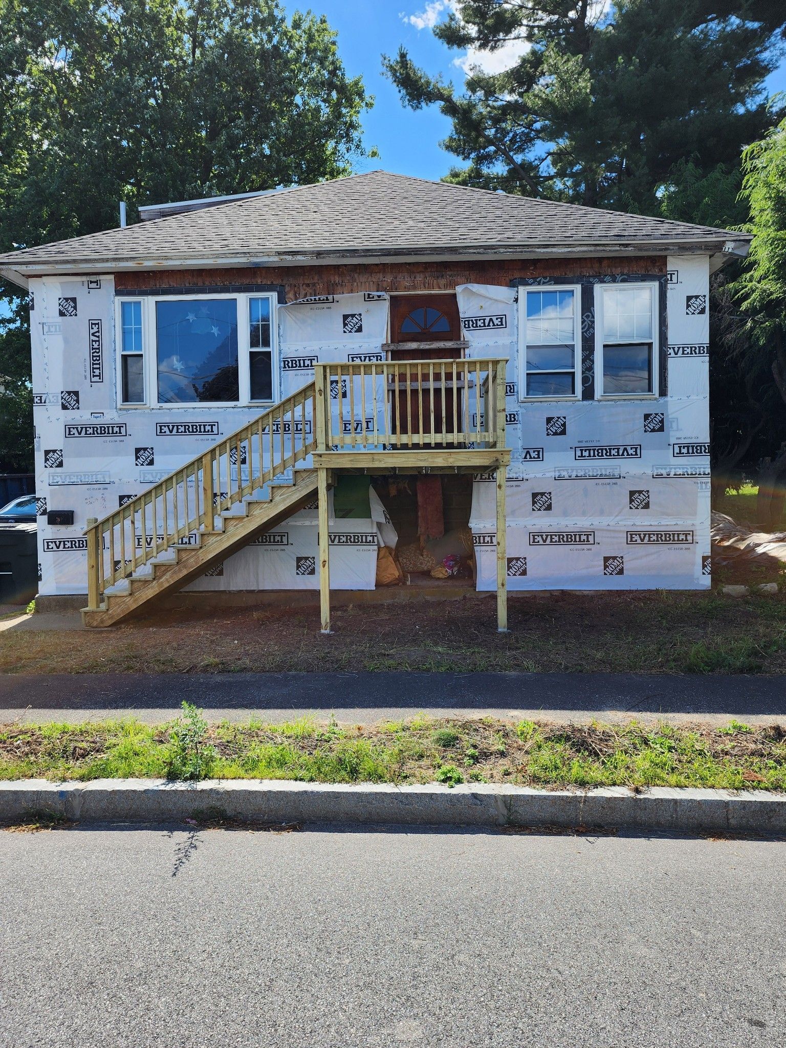 A house with stairs and a balcony is being remodeled.
