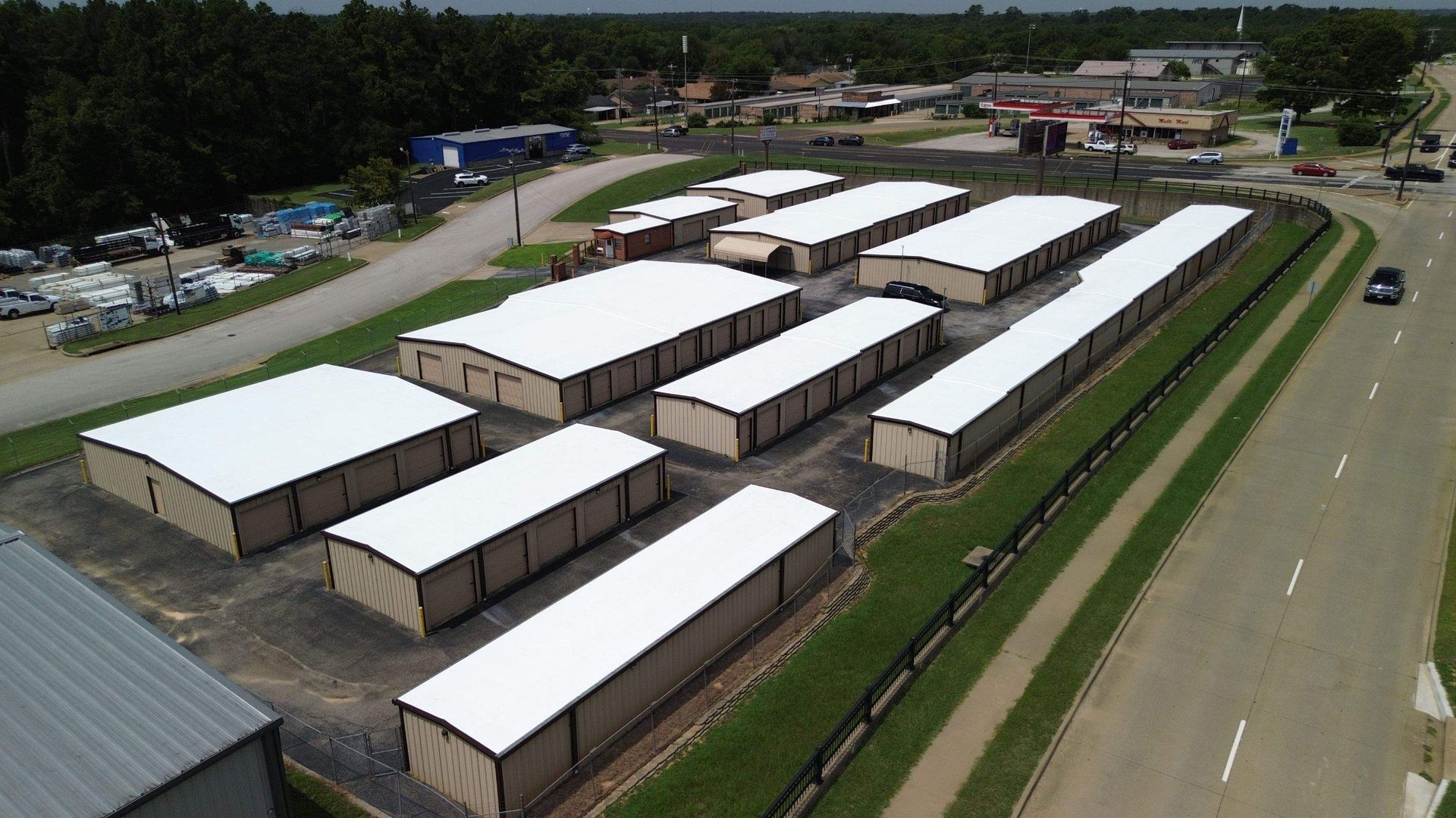 An aerial view of a row of storage units next to a highway