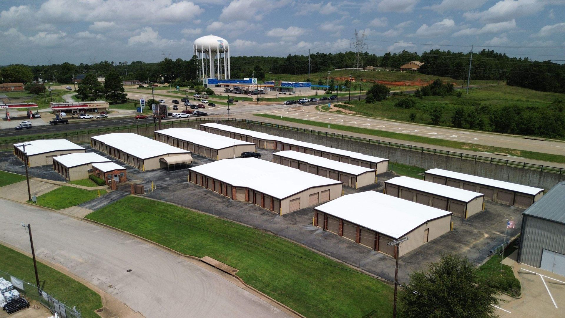 An aerial view of a storage facility with a water tower in the background.