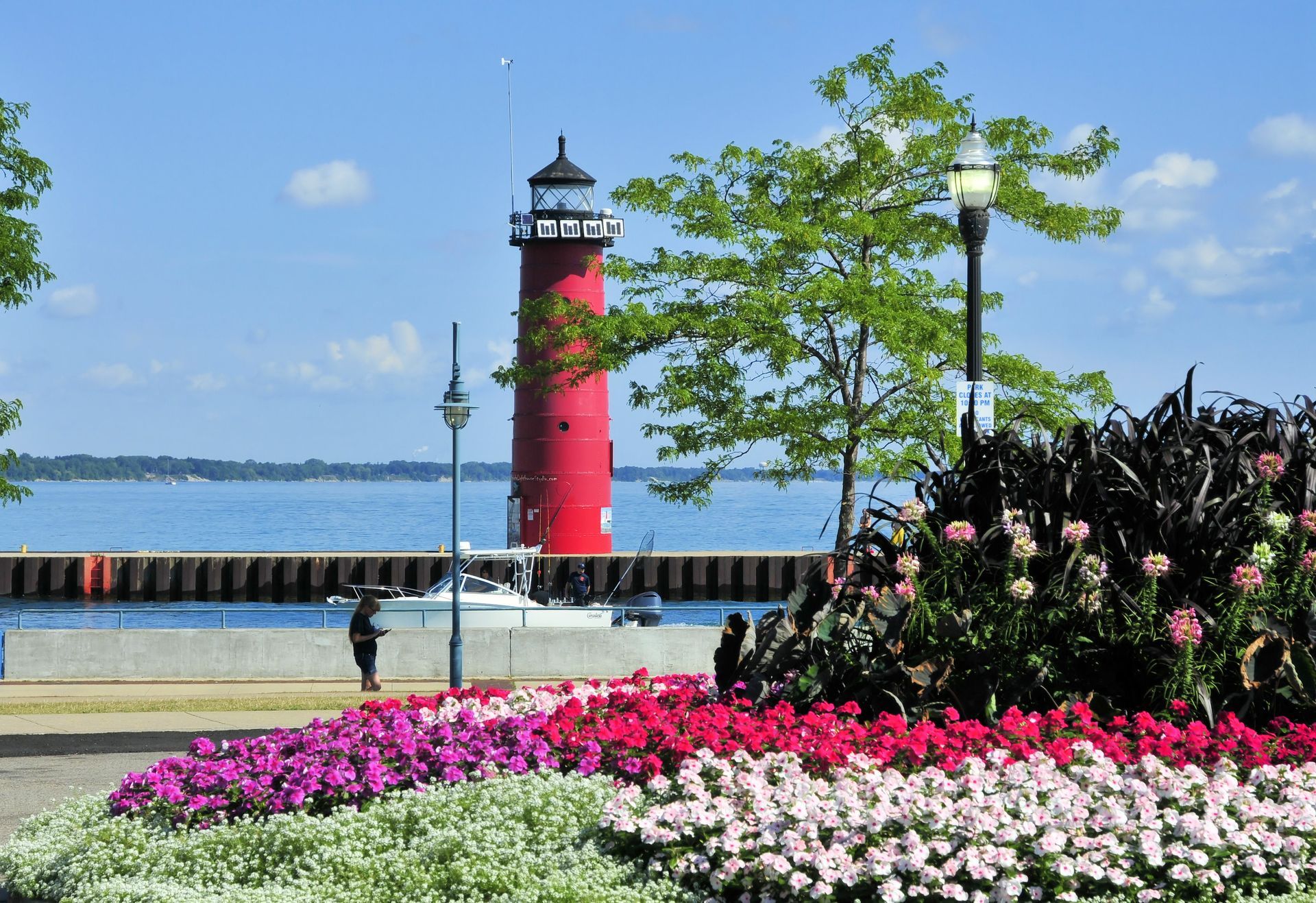 Kenosha's vibrant waterfront - lighthouse and boat in the distance with beautiful landscaping in the forefront