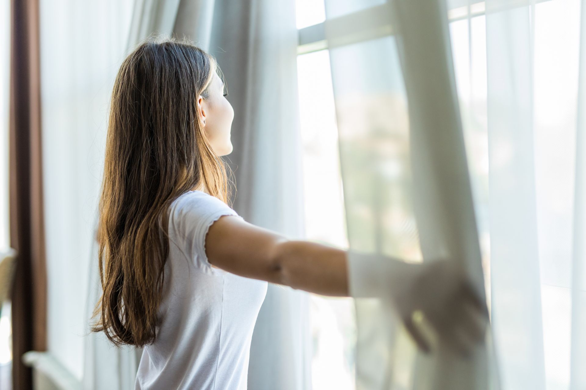 A person next to an open window, early AM