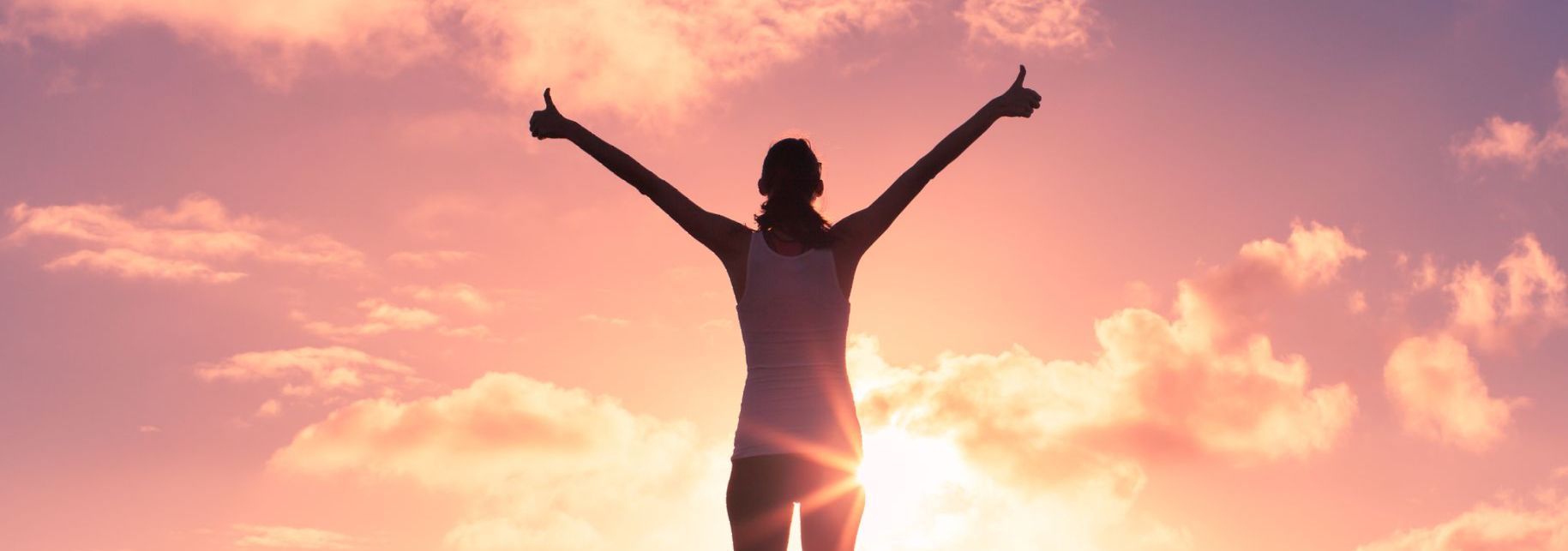 a woman with her arms outstretched giving a thumbs up