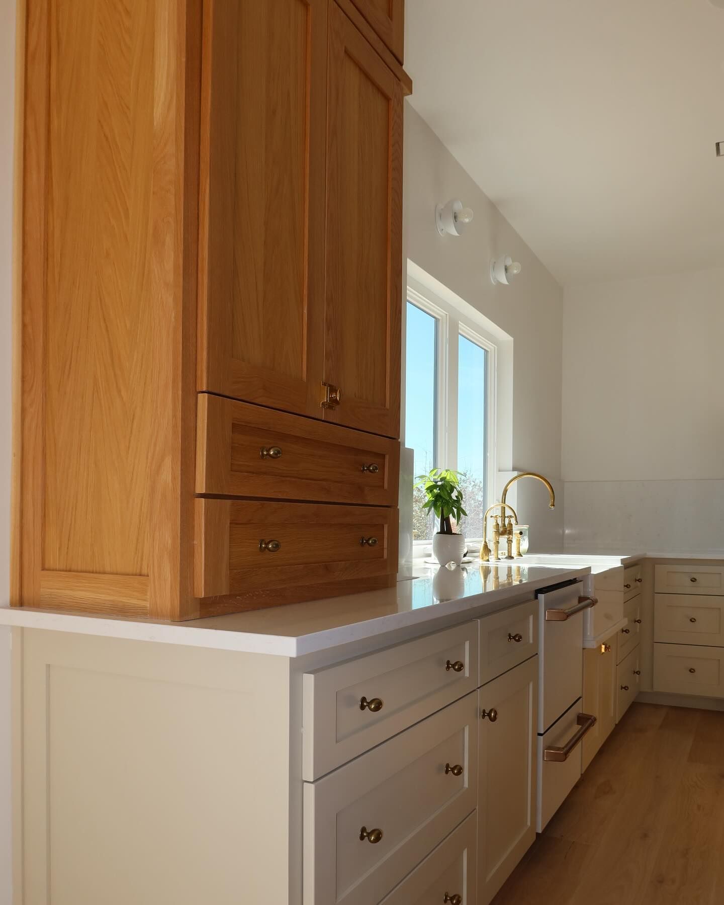 A kitchen with wooden cabinets and white drawers