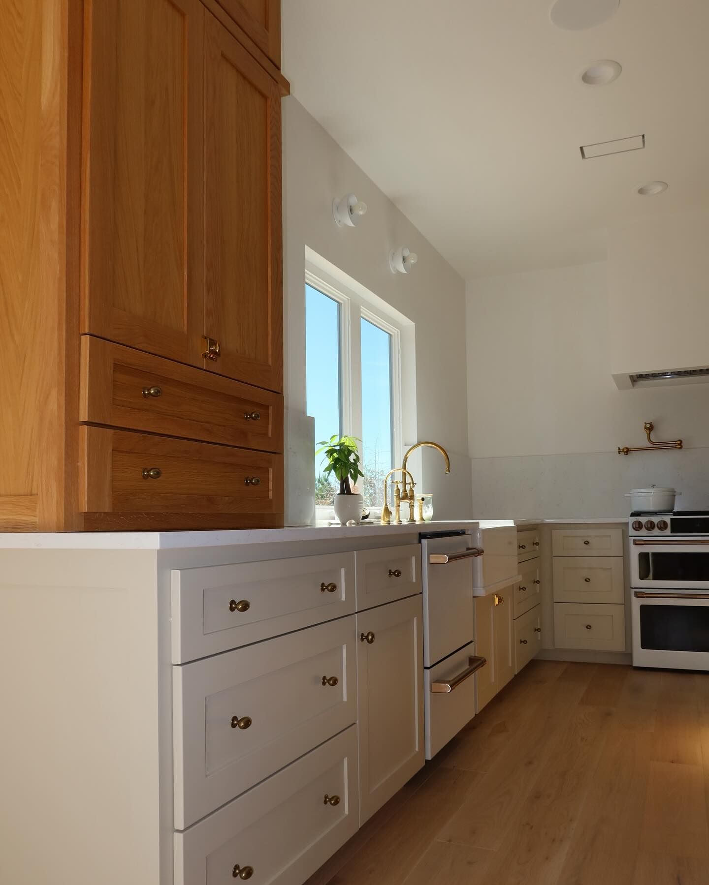 A kitchen with wooden cabinets and white drawers