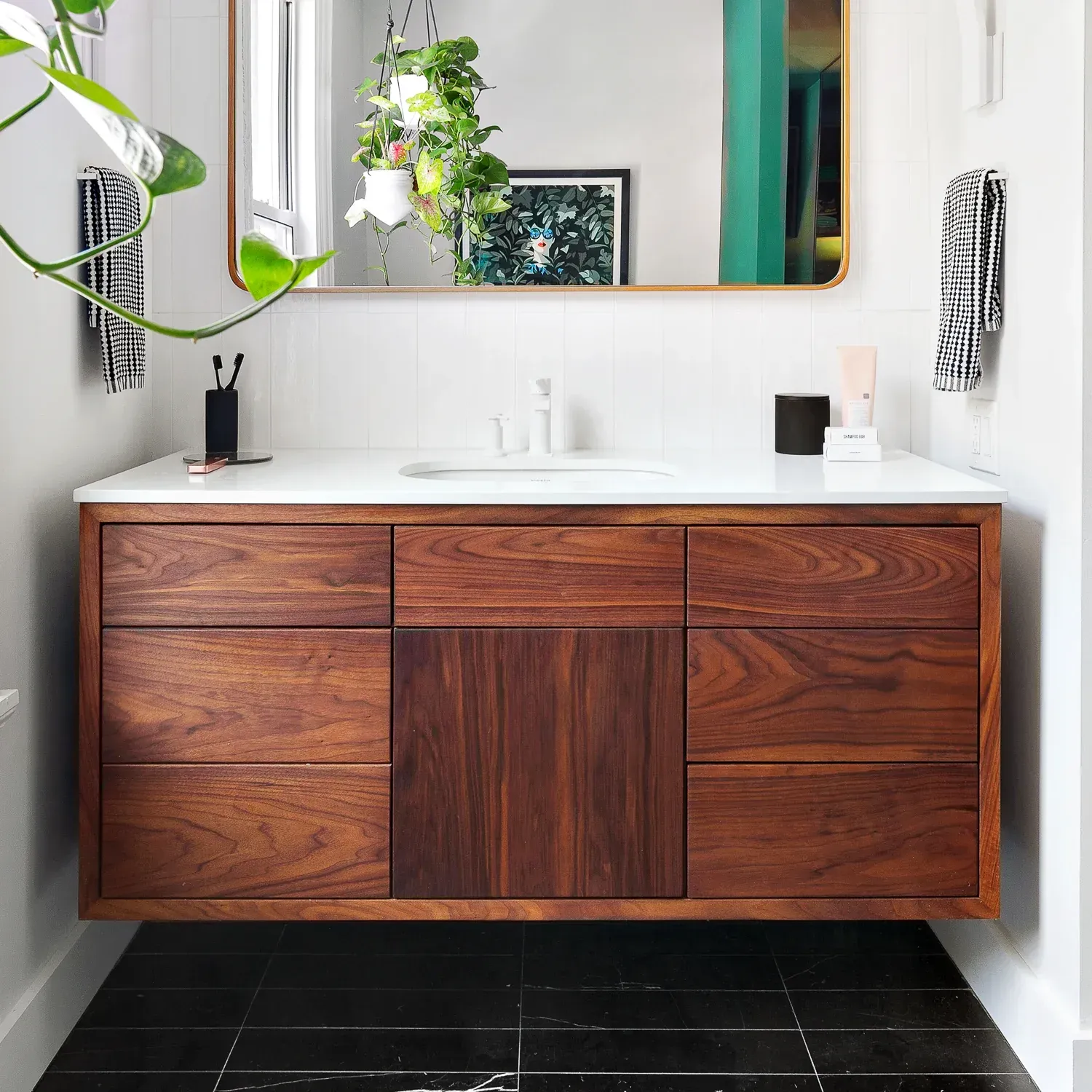 A bathroom with a wooden vanity and a mirror