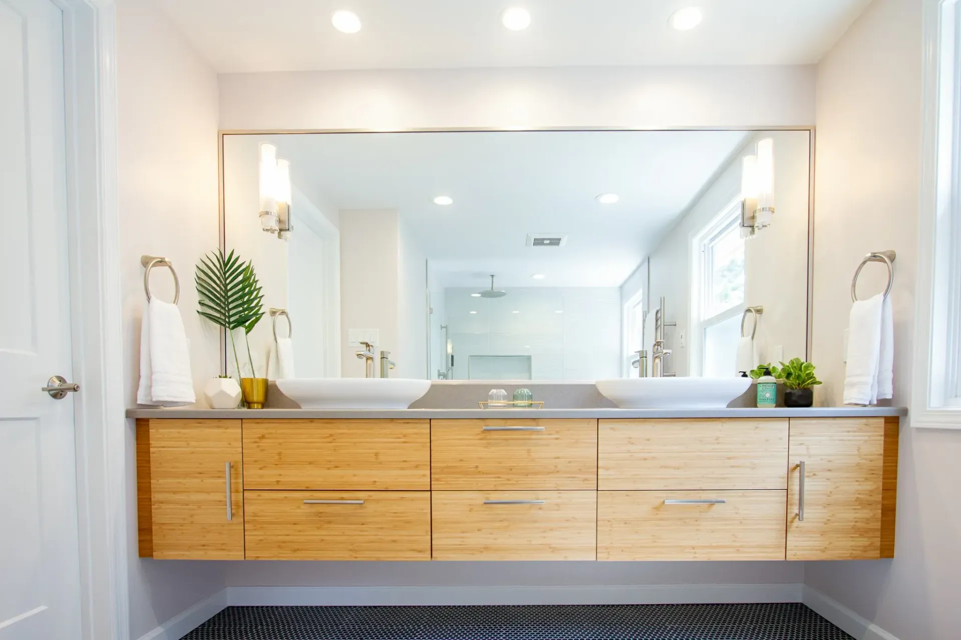 A bathroom with two sinks and a large mirror.