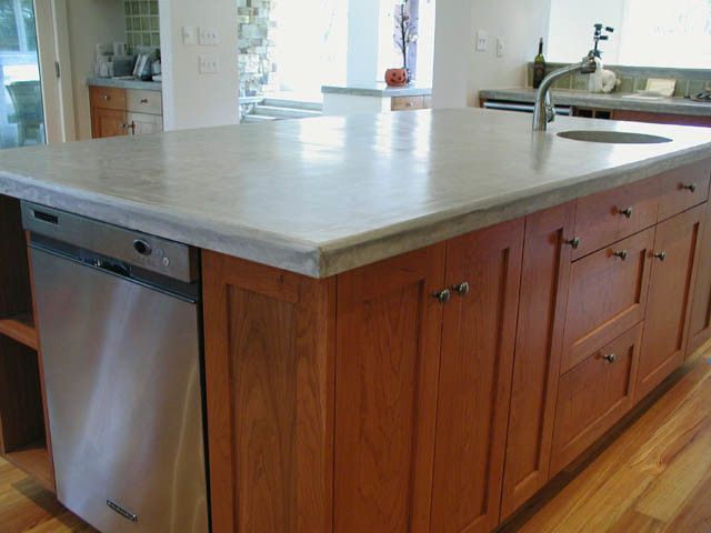A kitchen with wooden cabinets and a stainless steel dishwasher