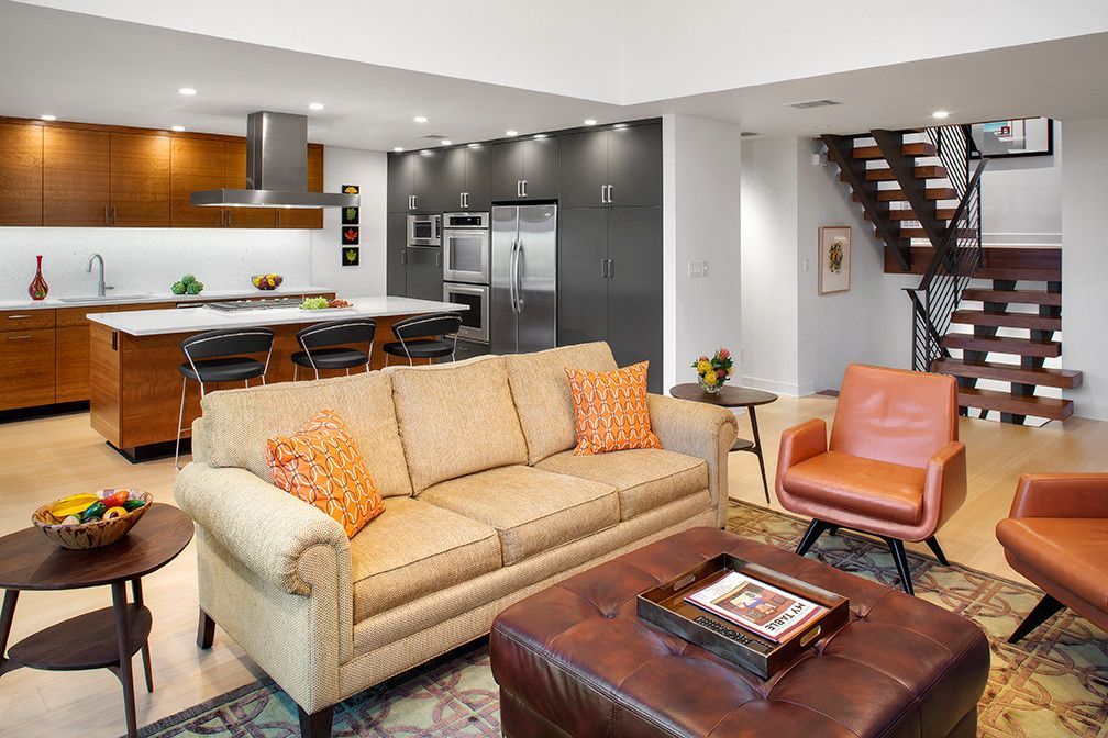A living room with a couch ottoman and chairs