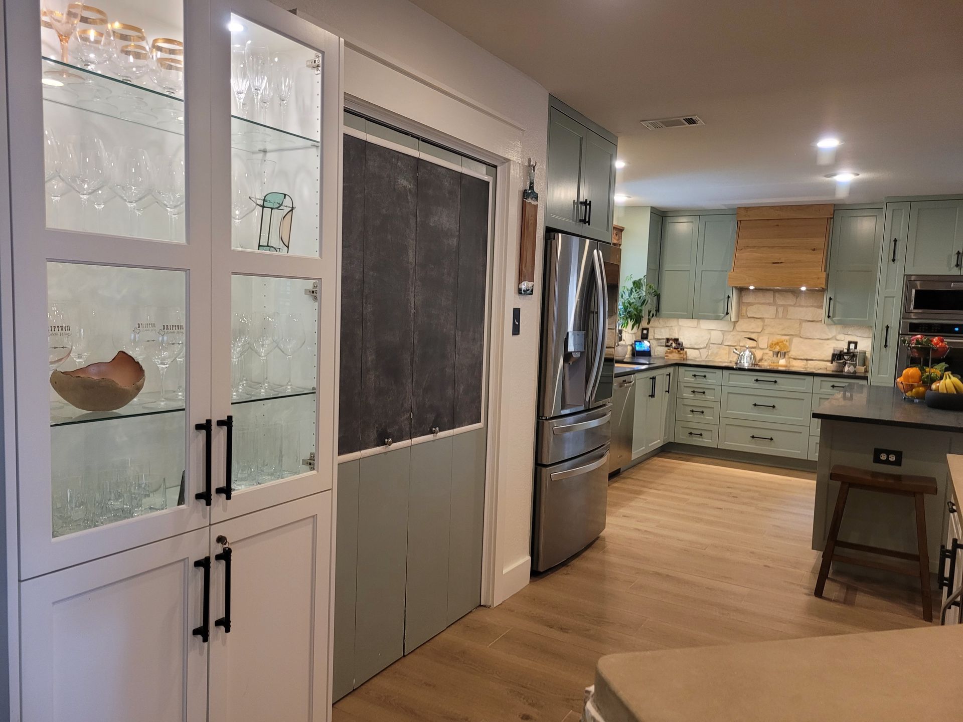 A kitchen with stainless steel appliances and a chalkboard on the wall.